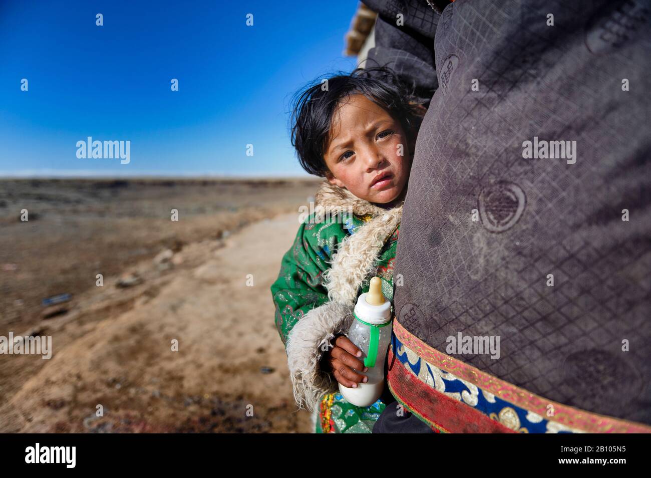 I piccoli tibetani che crescono in regioni remote crescono molto vicino ai loro genitori, che fin dalla prima età insegnano loro come intraprendere la vita in un ambiente così duro. Altopiano tibetano remoto Foto Stock