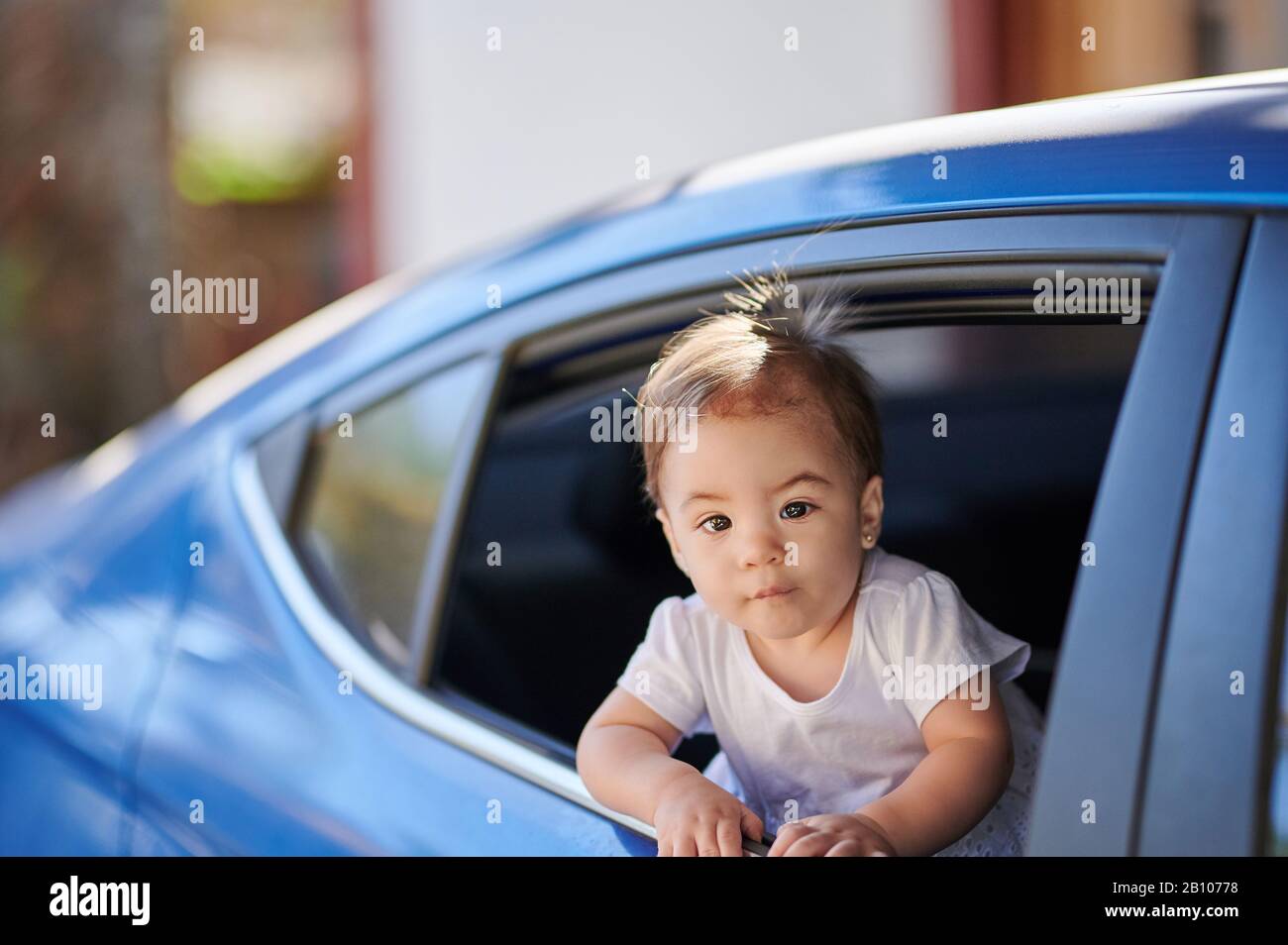 Ragazza carina del bambino in viaggio in auto guardando dalla finestra Foto Stock