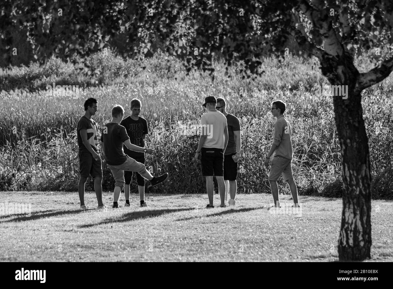 I giovani uomini gironzano calci nel parco Foto Stock