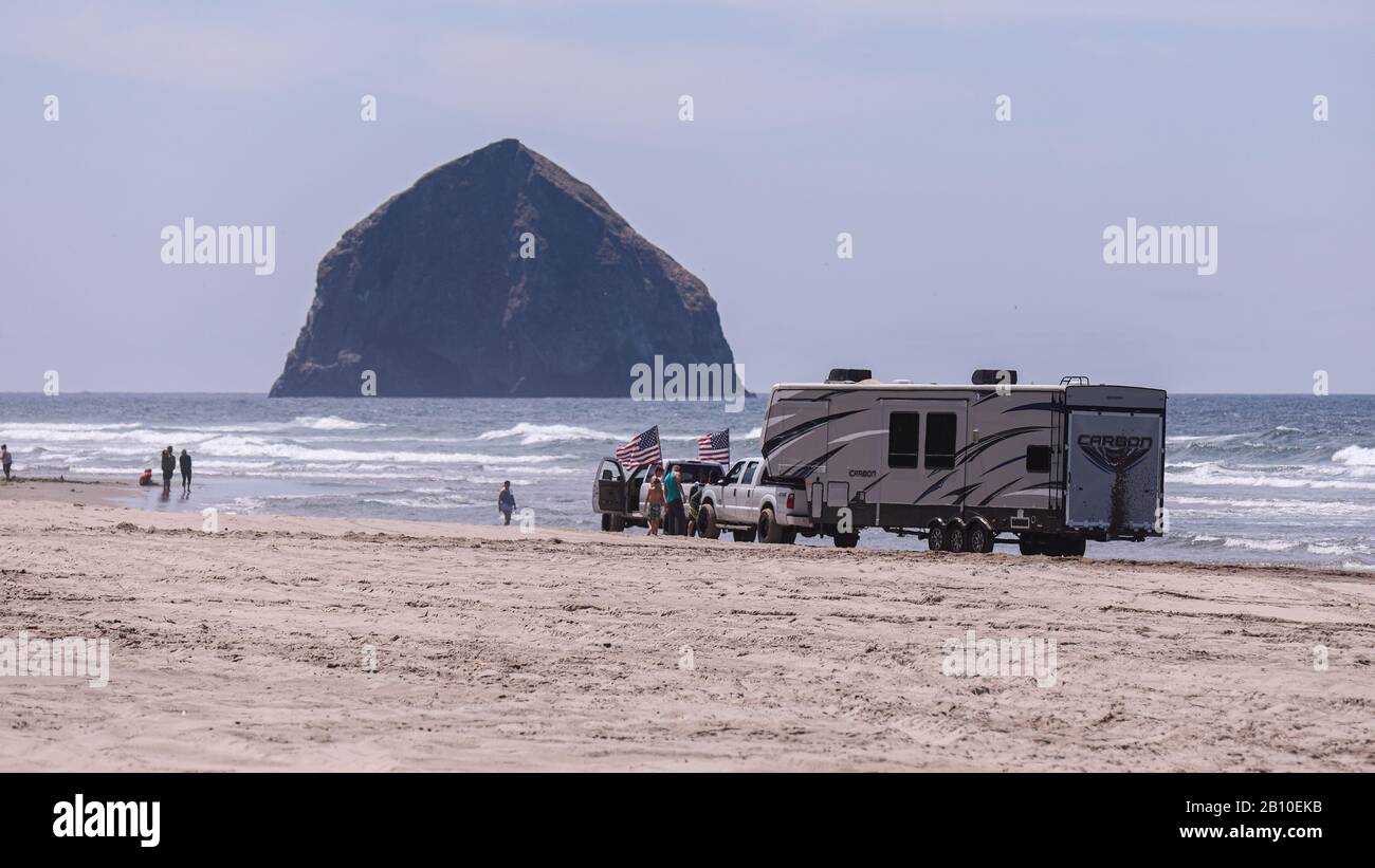 Pacific City, Oregon USA - 07 luglio 2019: Due pick-up che tirano un grande rimorchio per camper bloccato su una spiaggia di Cape Kiwanda in una giornata di sole Foto Stock
