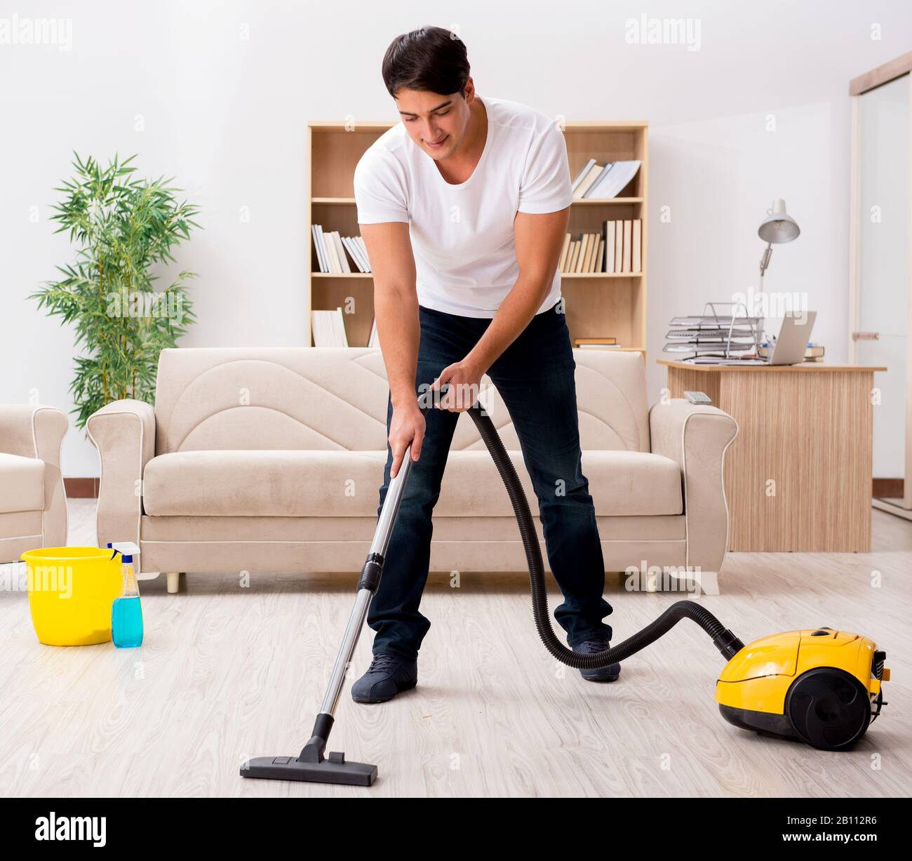 L'uomo che pulisce a casa con l'aspirapolvere Foto stock - Alamy