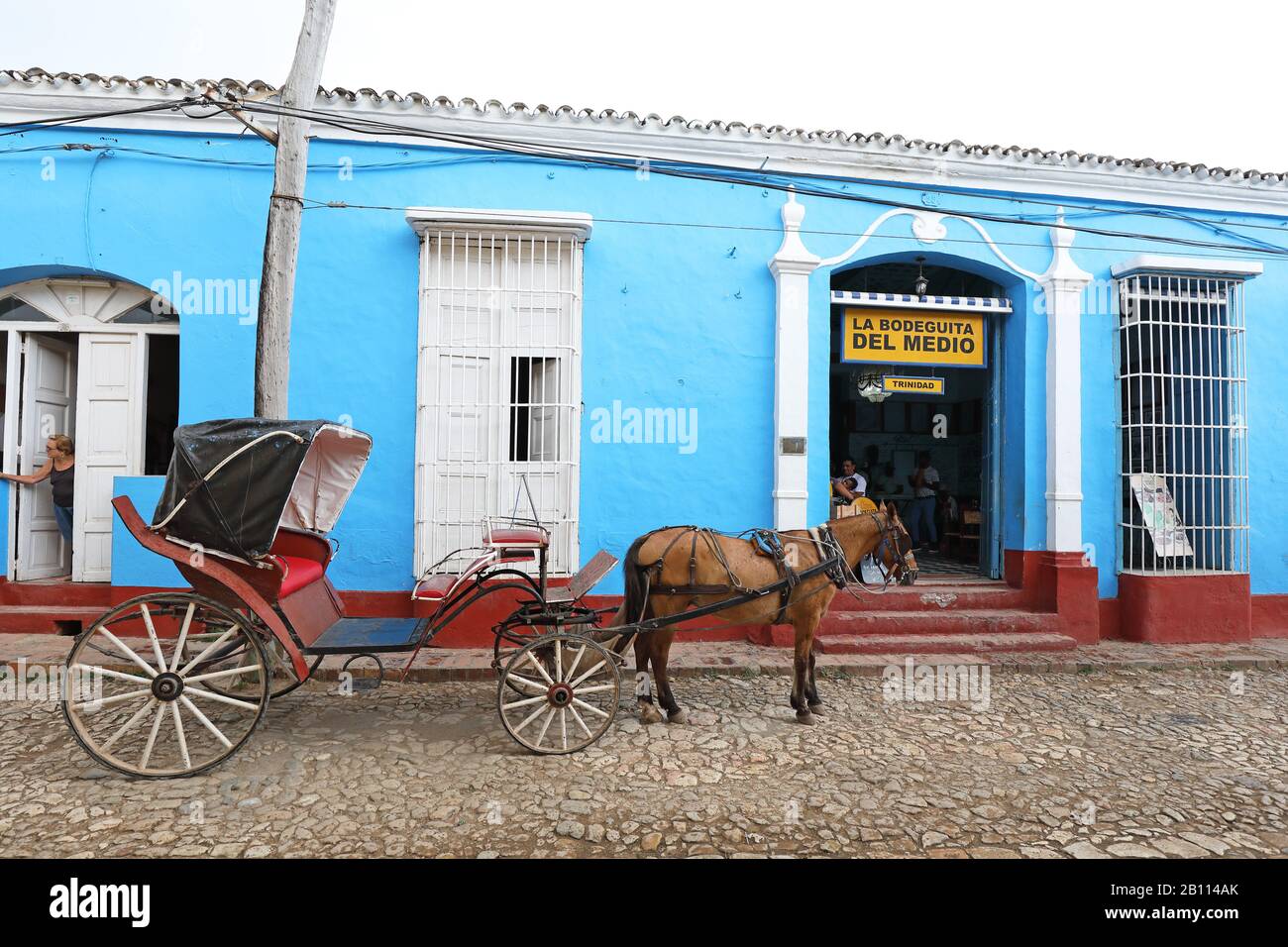 Carrozza trainata da cavalli di fronte a un wine bar, Cuba, Trinidad Foto Stock