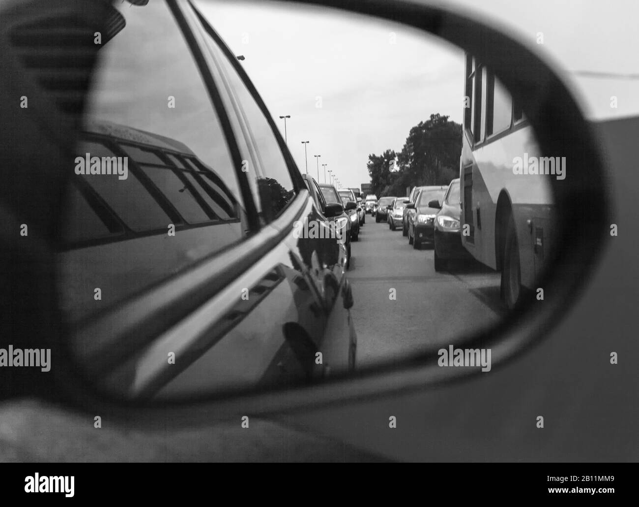 Riflesso di un ingorgo in uno specchio laterale. Applicato il vecchio filtro fotografico bianco e nero Foto Stock