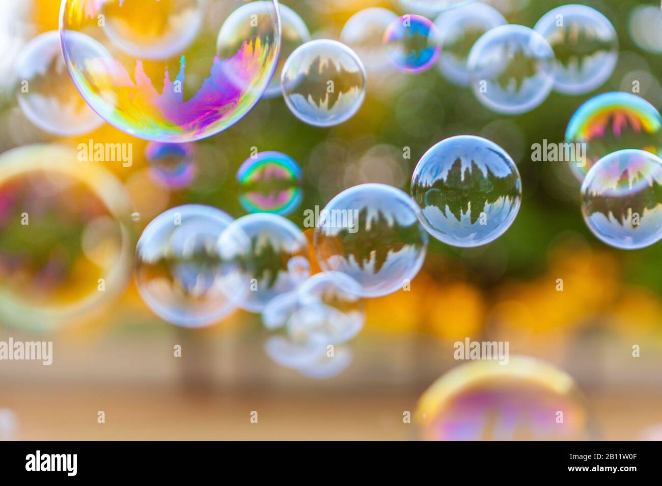 Grande gruppo di bolle di sapone pieno di colori e riflessi Foto Stock