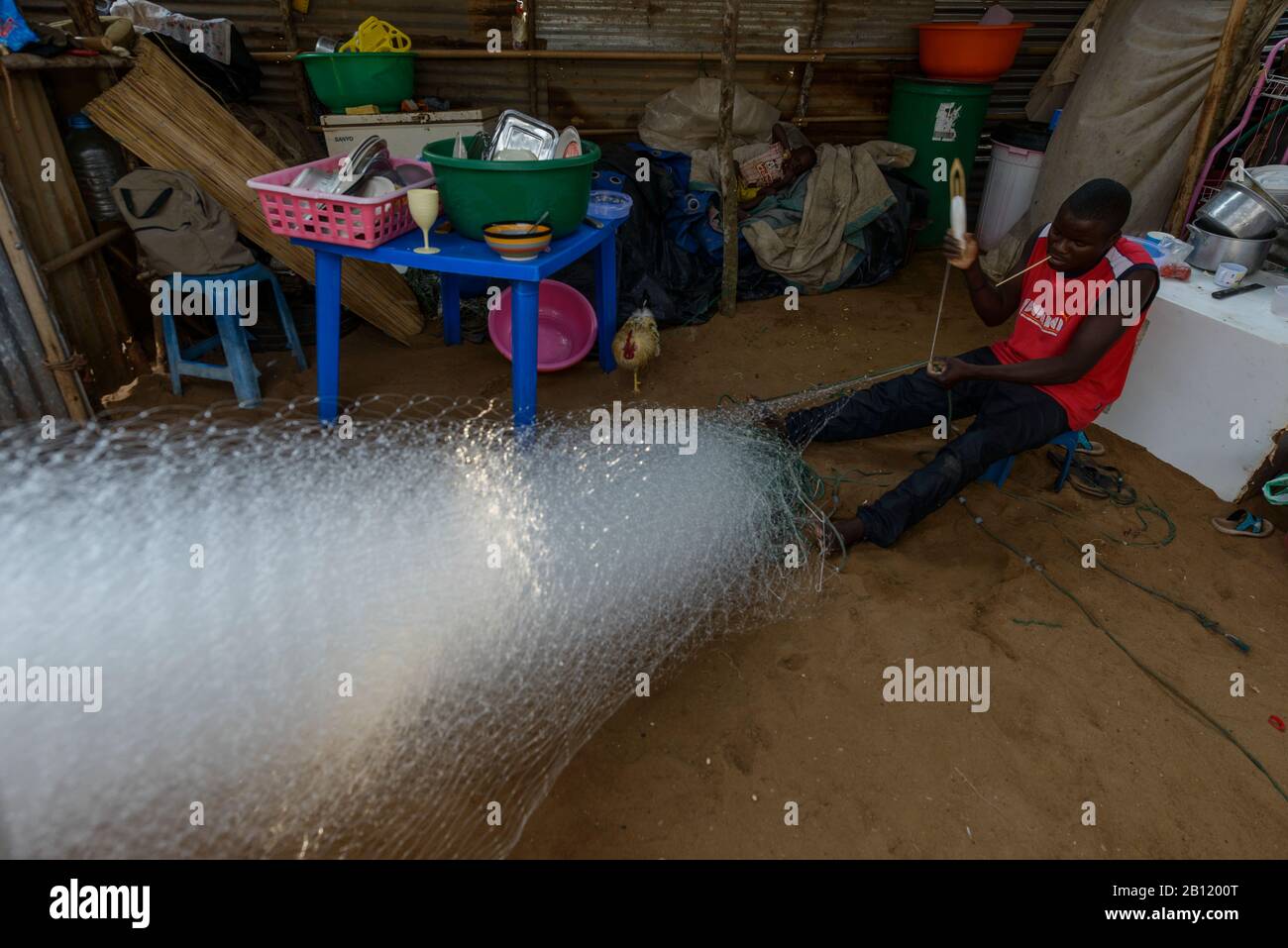 Pescatore angolano ripara la sua rete, Angola, Africa Foto Stock