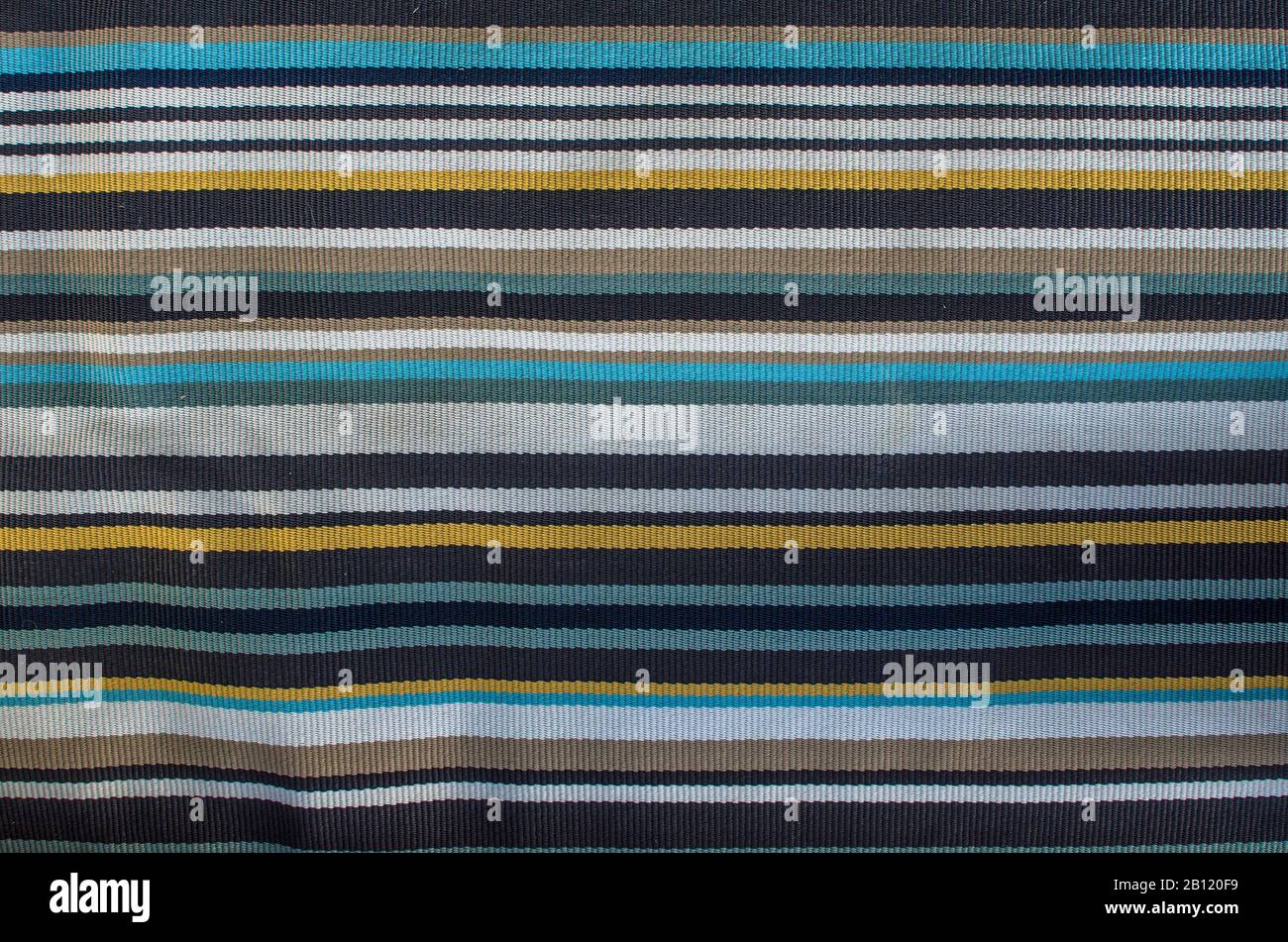 Tappeto da pavimento con strisce texture sfondo. Bianco, giallo, blu, nero, grigio tappeto a strisce Foto Stock