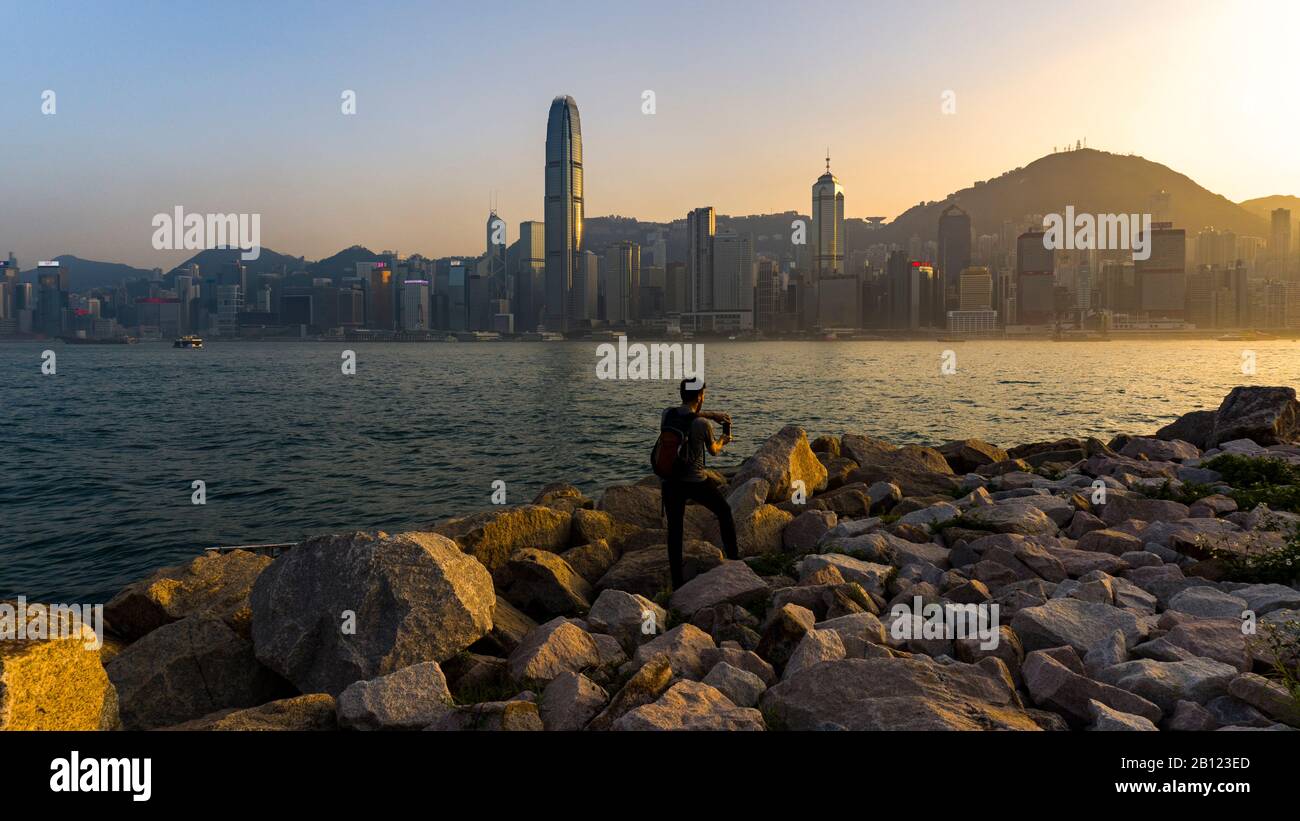 Hong Kong - Gennaio 2020 : Backpacker Scattare La Foto Dello Skyline Di Hong Kong A Twilight, Long Shot, Livello Dell'Occhio Foto Stock