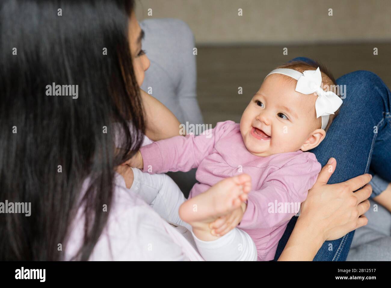 La madre siede su una sedia con il bambino Foto Stock