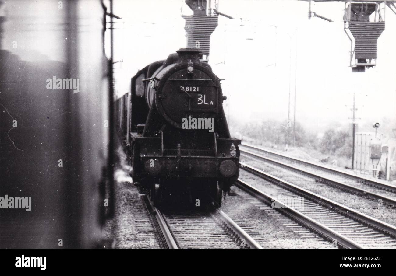 Foto vintage in bianco e nero di locomotiva a vapore - 48121 si dirige a nord su un treno a tramoggia vuota vicino alla stazione di Bletchley Settembre 1965. Foto Stock