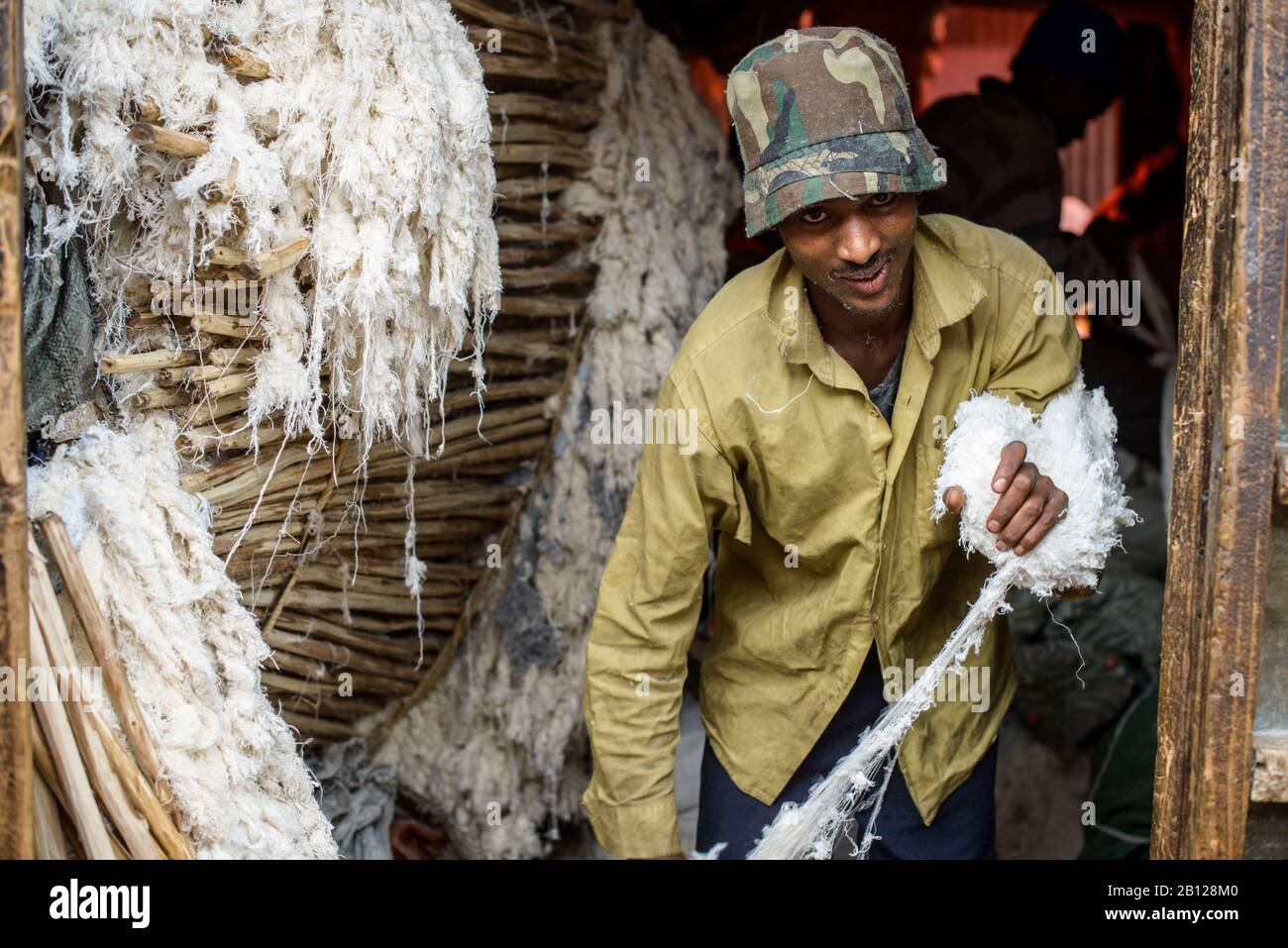 Un uomo lavora cotone per materassi nel mercato gigante di Addis Abeba, Etiopia Foto Stock