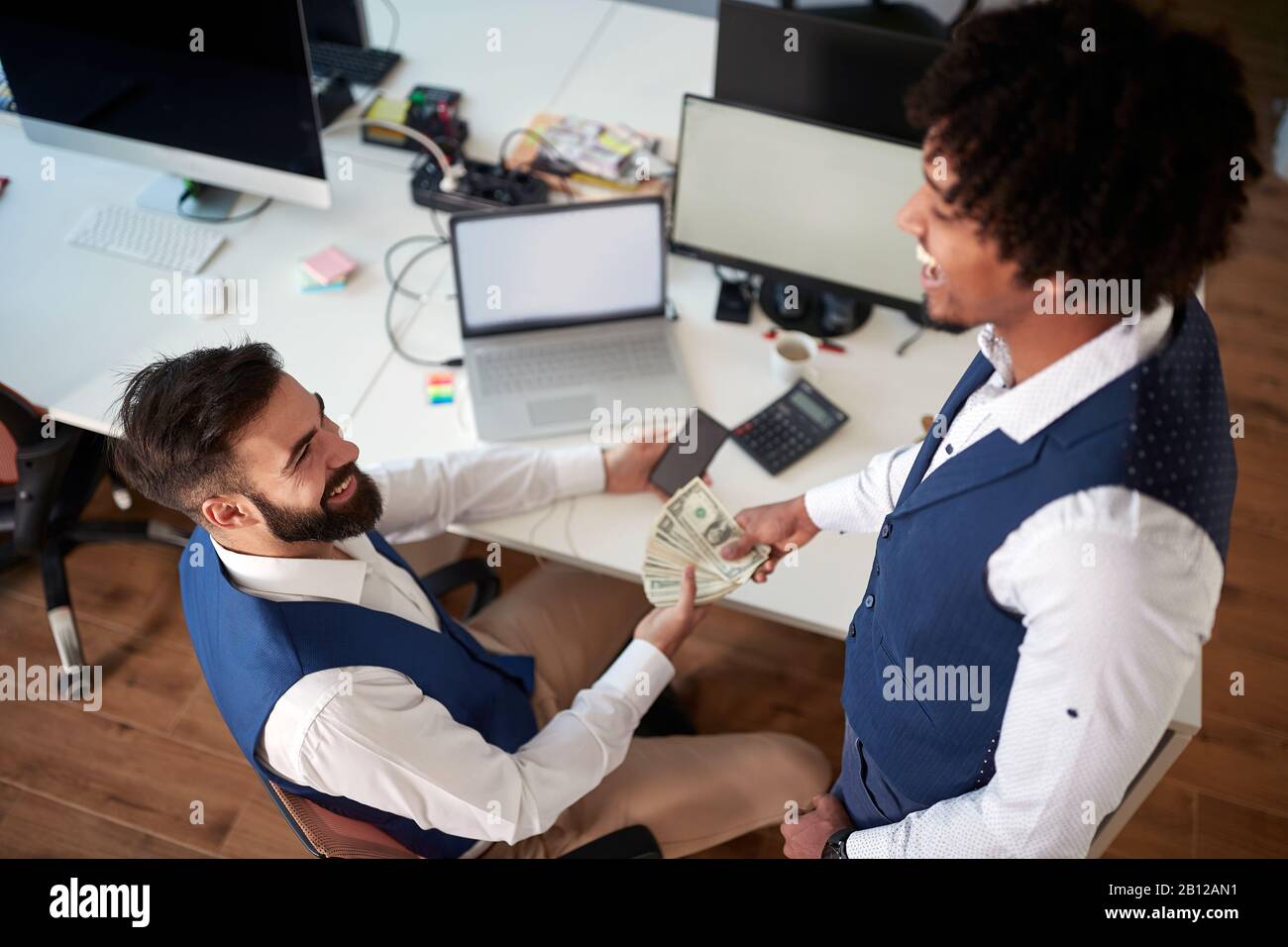 due colleghi , multietnici, in ufficio che hanno scambio di denaro. business, contanti, tangente, corruzione, prestito, dare, prendere, concetto Foto Stock