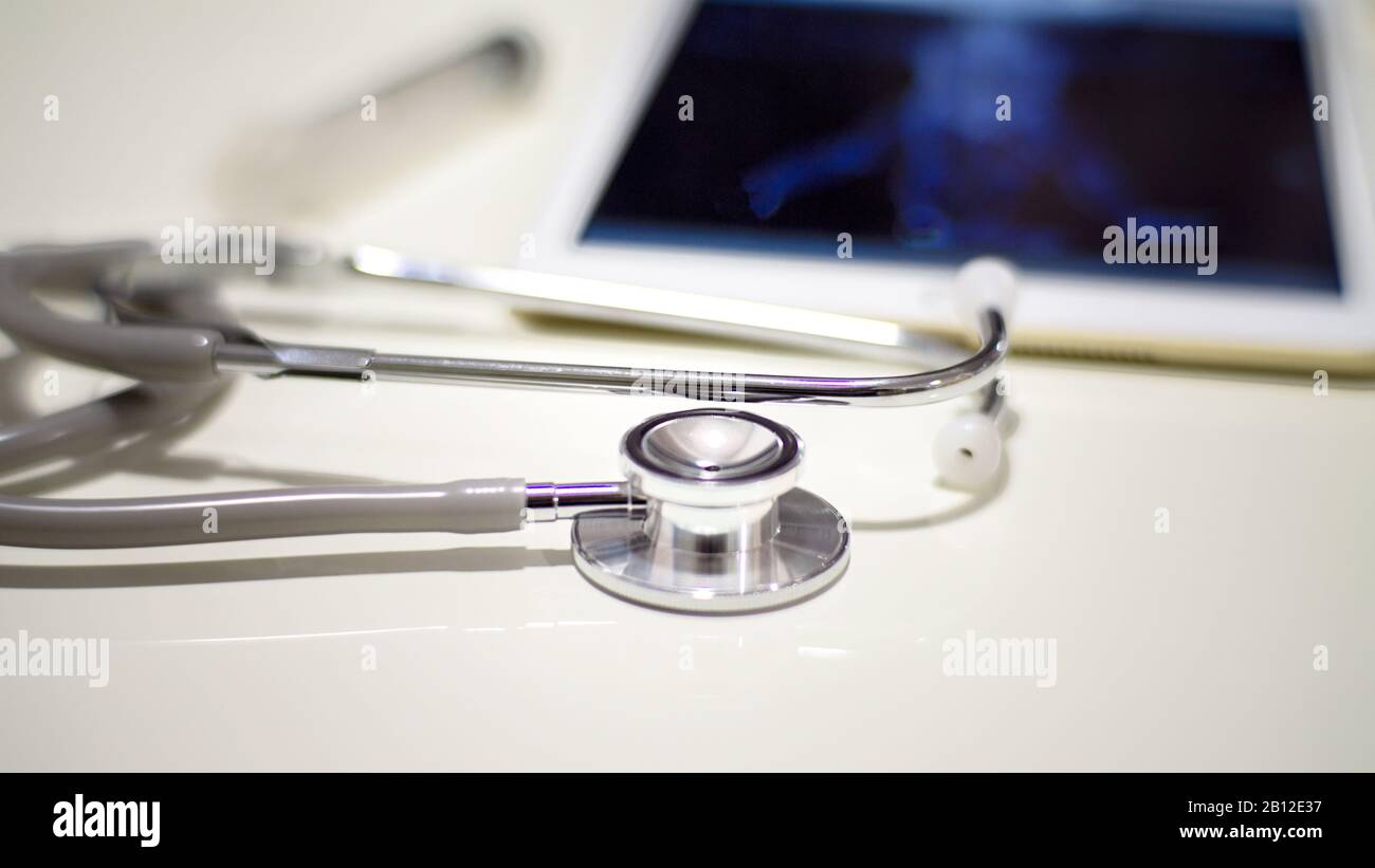 Chiuso su stetoscopio e tablet che visualizzano la scansione dell'attività cerebrale sul tavolo, Medical workplace. Concetto di assistenza sanitaria. Foto Stock