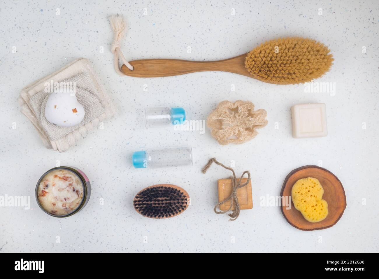 accessori bagno, saponi, spazzola per il corpo, scrub con foglie di rosa, bottiglie per cosmetici, spugna su sfondo bianco, vista dall'alto, primo piano. Concetto di Spa Foto Stock