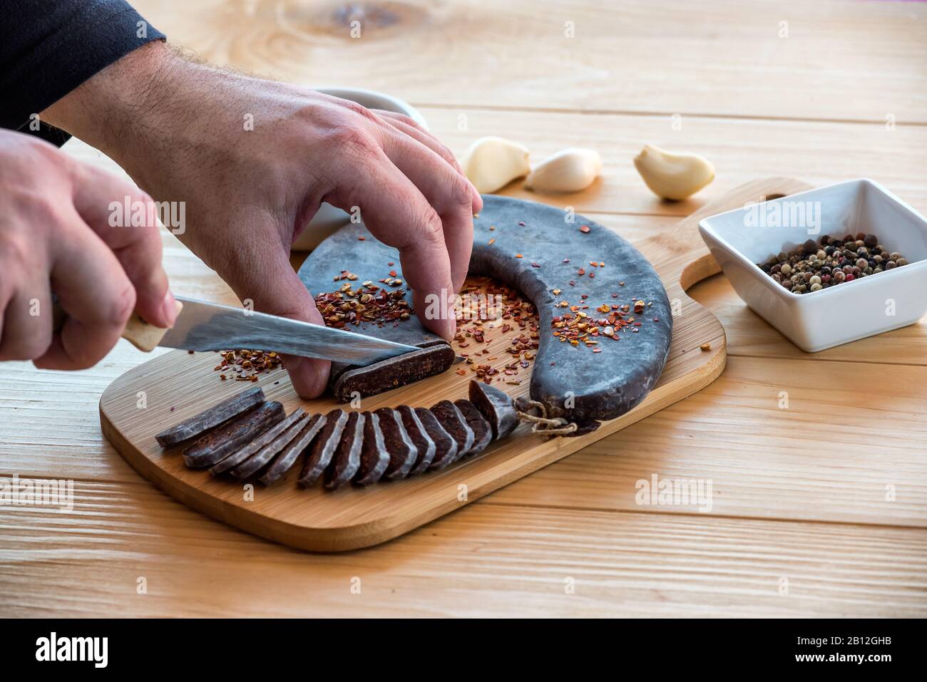 Uomo Mani taglio Fette di speciale Pirot ferro di cavallo salsiccia stirata - Peglana Pirotska kobasica, fatta di carne di vitello, pecora e capra Foto Stock