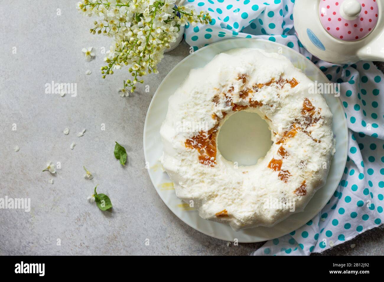Dessert di Pannacotta. Cottage souffle di formaggio panna cotta con albicocche e decorazioni di cocco su una pietra o ardesia su un piano di lavoro leggero. Vista dall'alto piano Lay ba Foto Stock