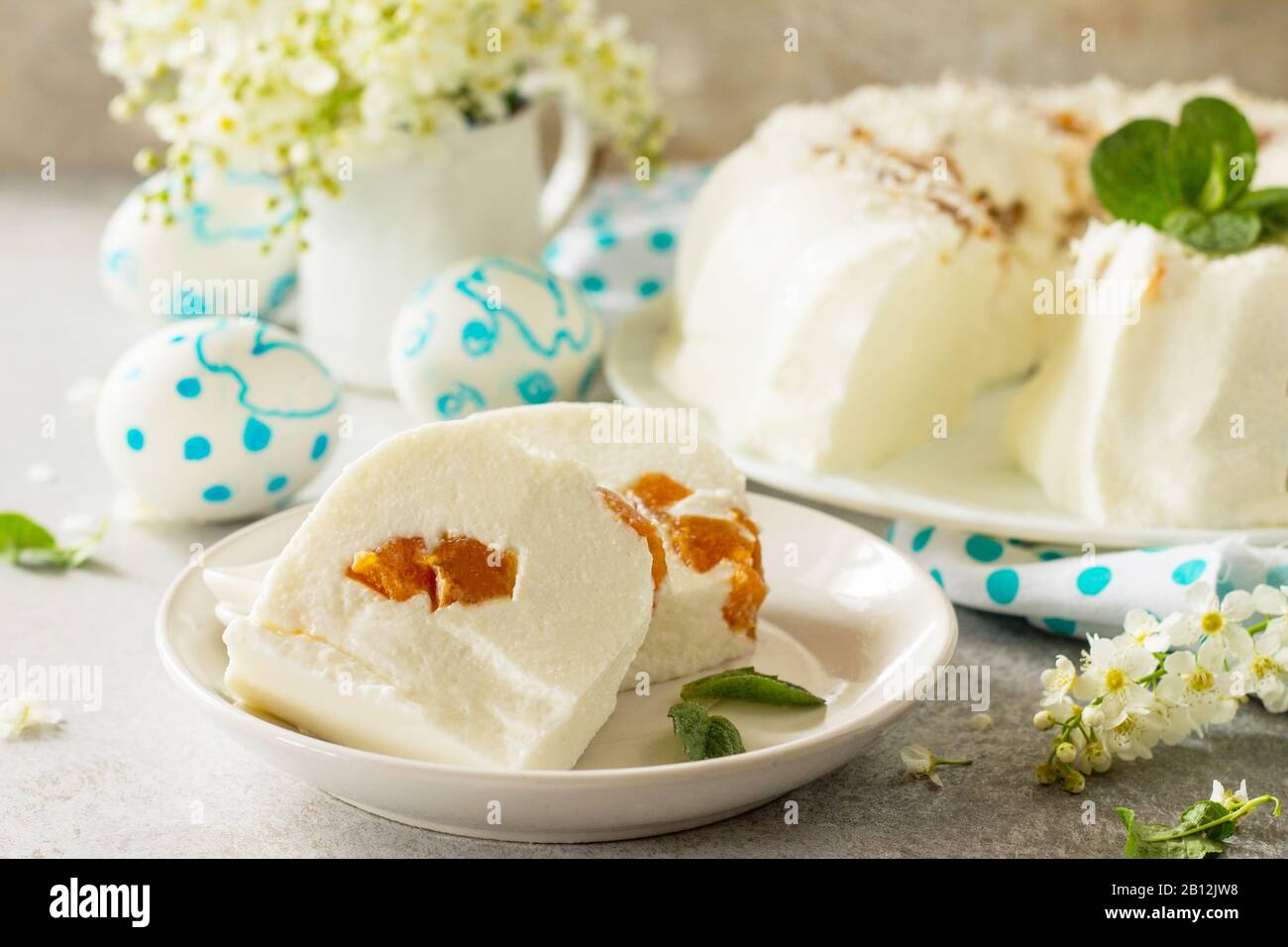 Dessert di Pannacotta. Cottage souffle di formaggio panna cotta con albicocche su una pietra o ardesia su un piano di lavoro leggero. Foto Stock