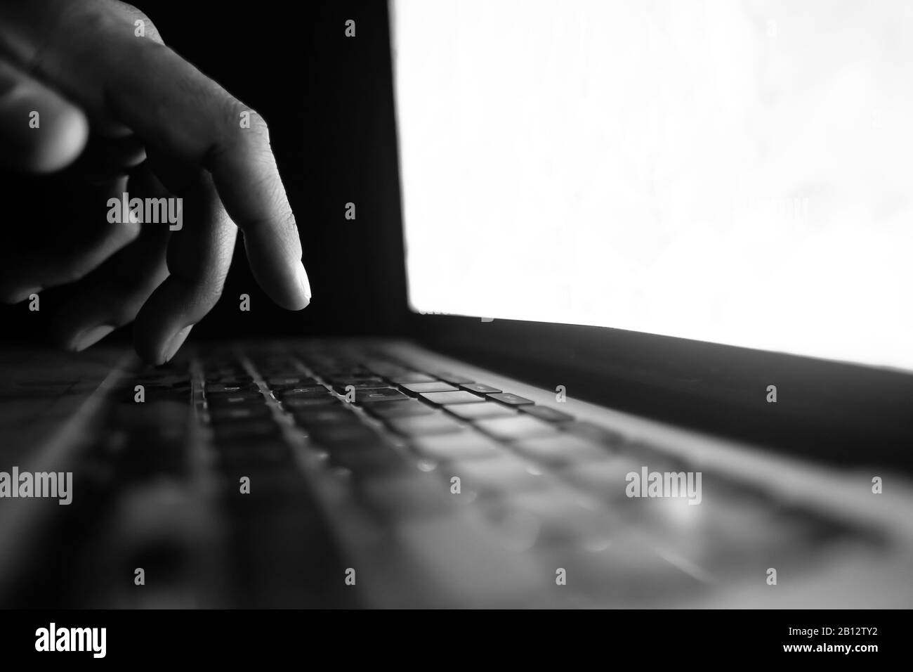 hacker mano che sigillano i dati dal computer portatile di notte Foto Stock