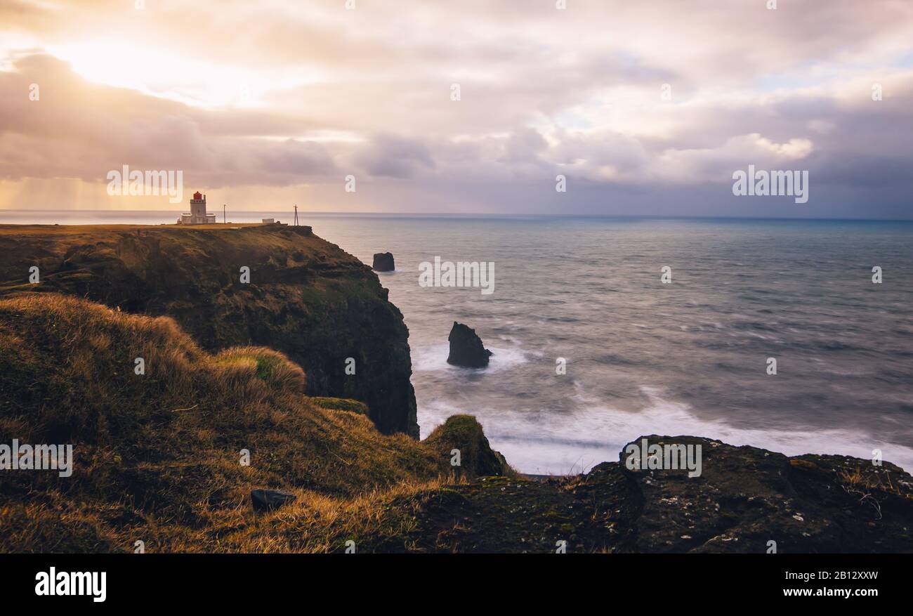 Una lunga esposizione del faro di Dyrholaey su una scogliera sopra l'oceano atlantico sulla costa meridionale dell'Islanda vicino a Vik. Foto Stock