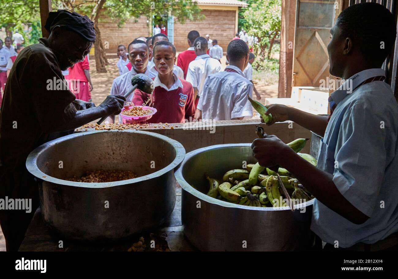Spendendo lo stufato di ceci e le banane per il pranzo presso la scuola secondaria di un grande ragazzo nel Kenya meridionale Foto Stock