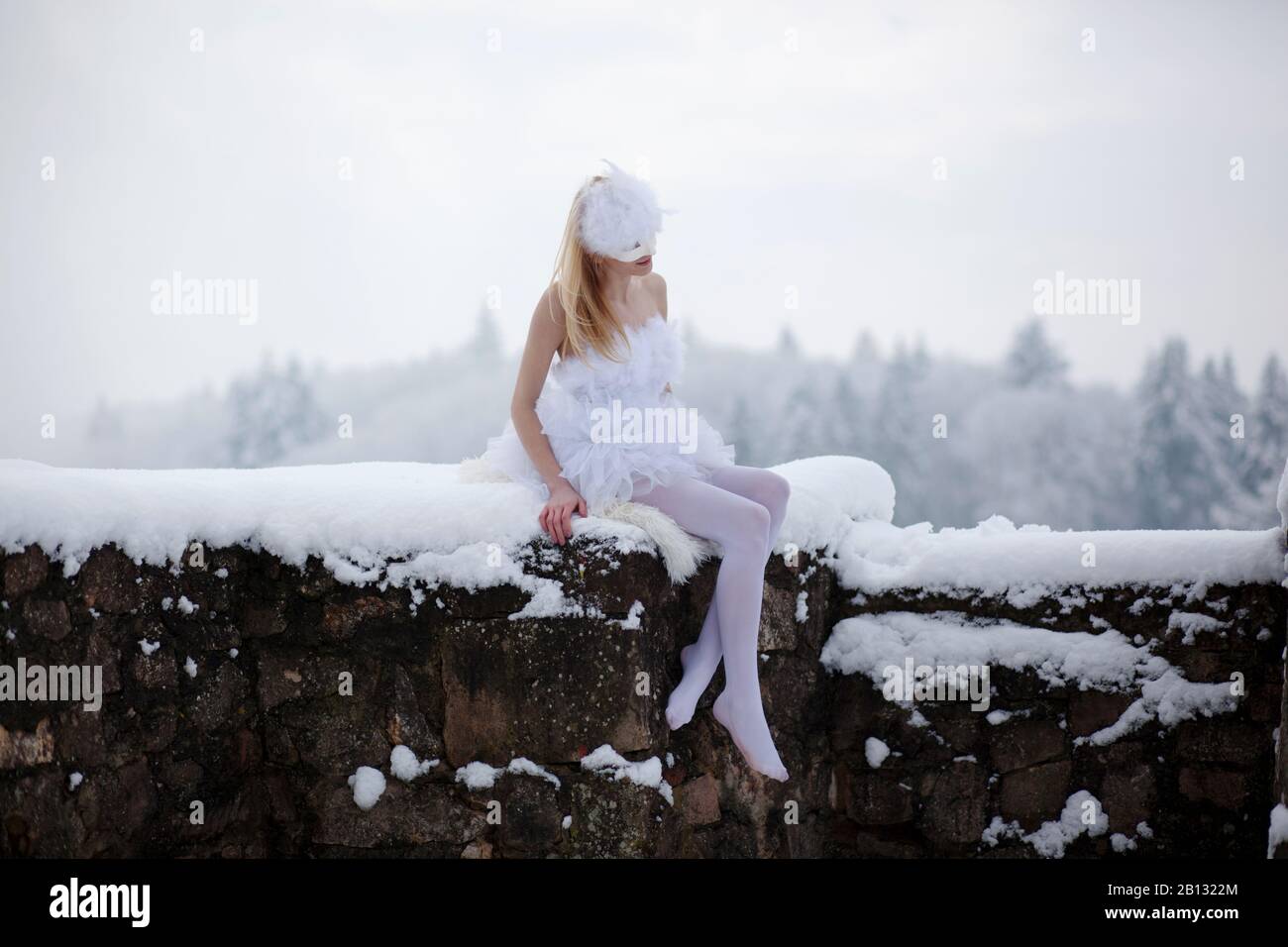 Ballerina seduta su una parete nella neve Foto Stock