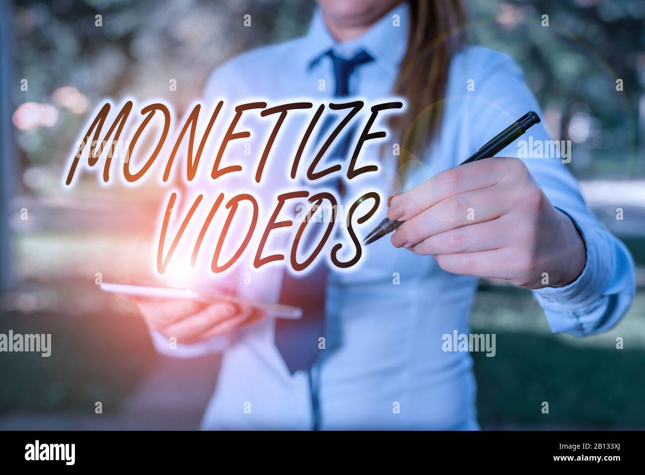 Scrittura a mano di testo Monetizza i video. Processo fotografico concettuale per guadagnare denaro dai tuoi video YouTube caricati Donna in una maglietta business blu Foto Stock