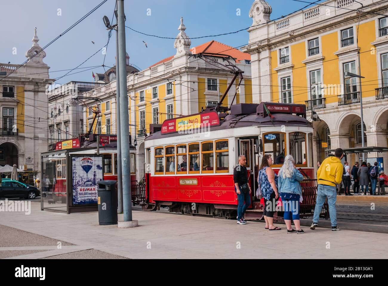 i turisti che arrivano a bordo di un tram rosso in piazza commerciale a lisbona, portogallo europa Foto Stock
