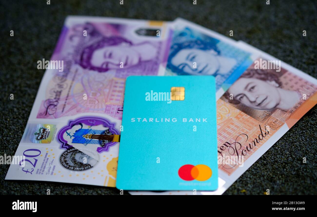 Carta Starling Bank e contanti sfocati sullo sfondo. Messa a fuoco selettiva. Foto Stock
