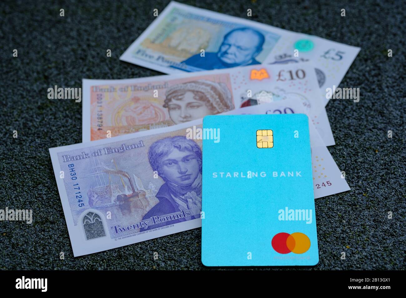 Carta Starling Bank e contanti sfocati sullo sfondo. Messa a fuoco selettiva. Foto Stock