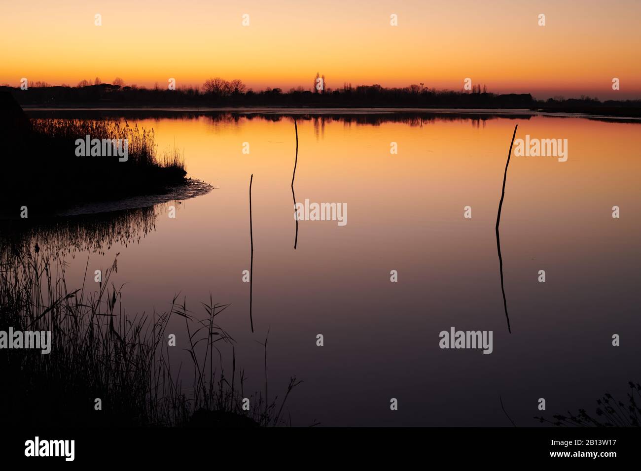 Caorle, Venezia, Italia, 01012020: Tramonto sulla laguna di Caorle con i colori del cielo arancione e il mare blu scuro. Foto Stock