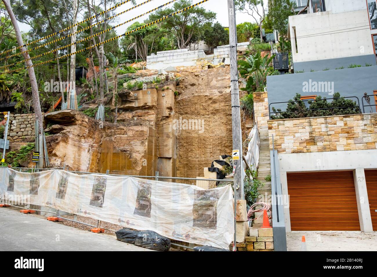 Australia, scavo profondo nella roccia per costruire una nuova casa di lusso in Palm Beach, Sydney, case adiacenti sostenuti durante lo scavo Foto Stock
