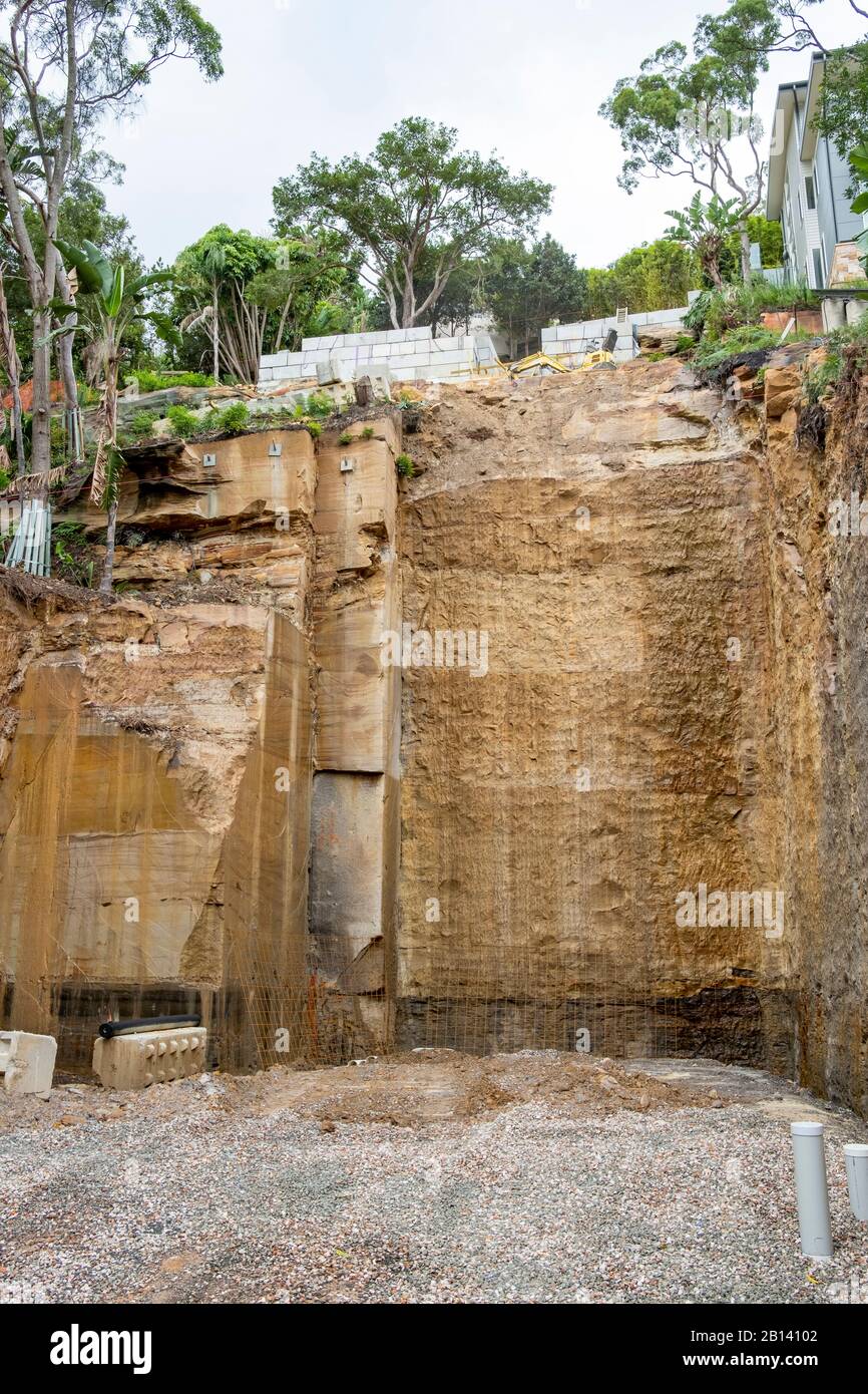 Australia, scavo profondo nella roccia per costruire una nuova casa di lusso in Palm Beach, Sydney, case adiacenti sostenuti durante lo scavo Foto Stock