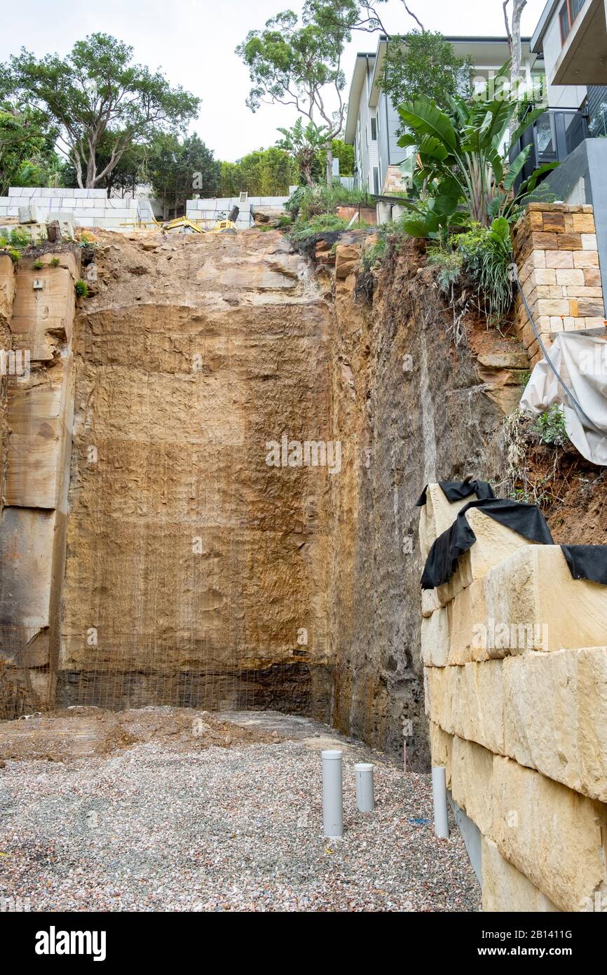 Australia, scavo profondo nella roccia per costruire una nuova casa di lusso in Palm Beach, Sydney, case adiacenti sostenuti durante lo scavo Foto Stock