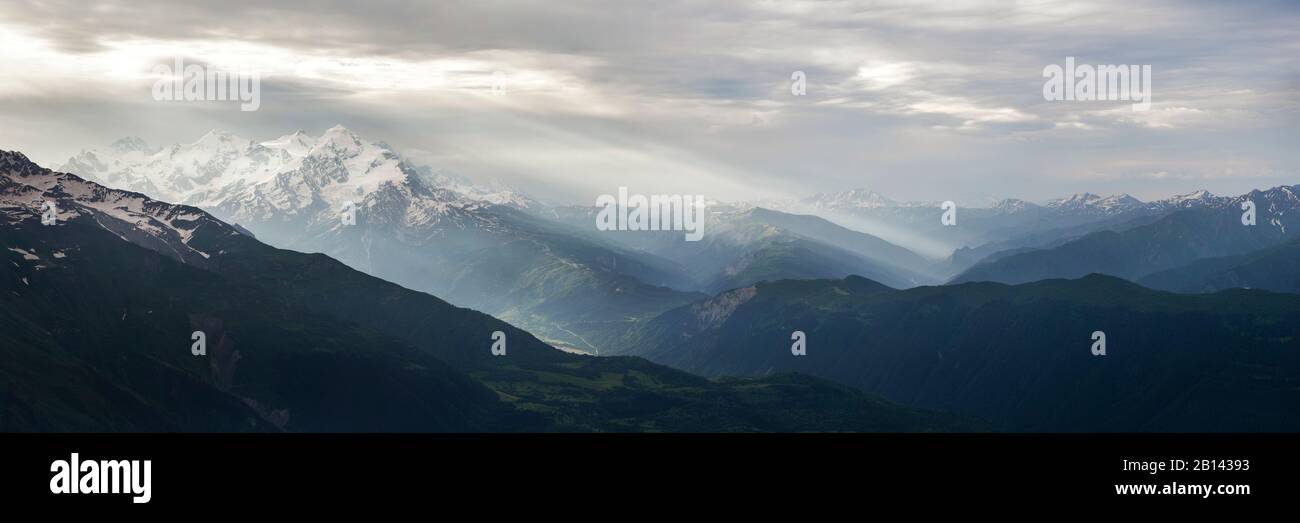 Sunrise striature da Mt Tetnuldi tra monti e le valli circostanti, Grande Caucaso, Superiore Svanetia, Georgia Foto Stock