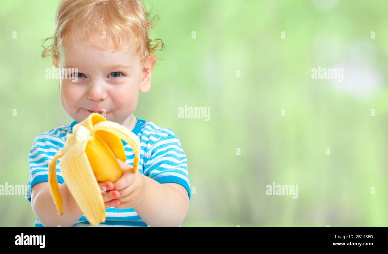 buon bambino che mangia frutta di banana Foto Stock