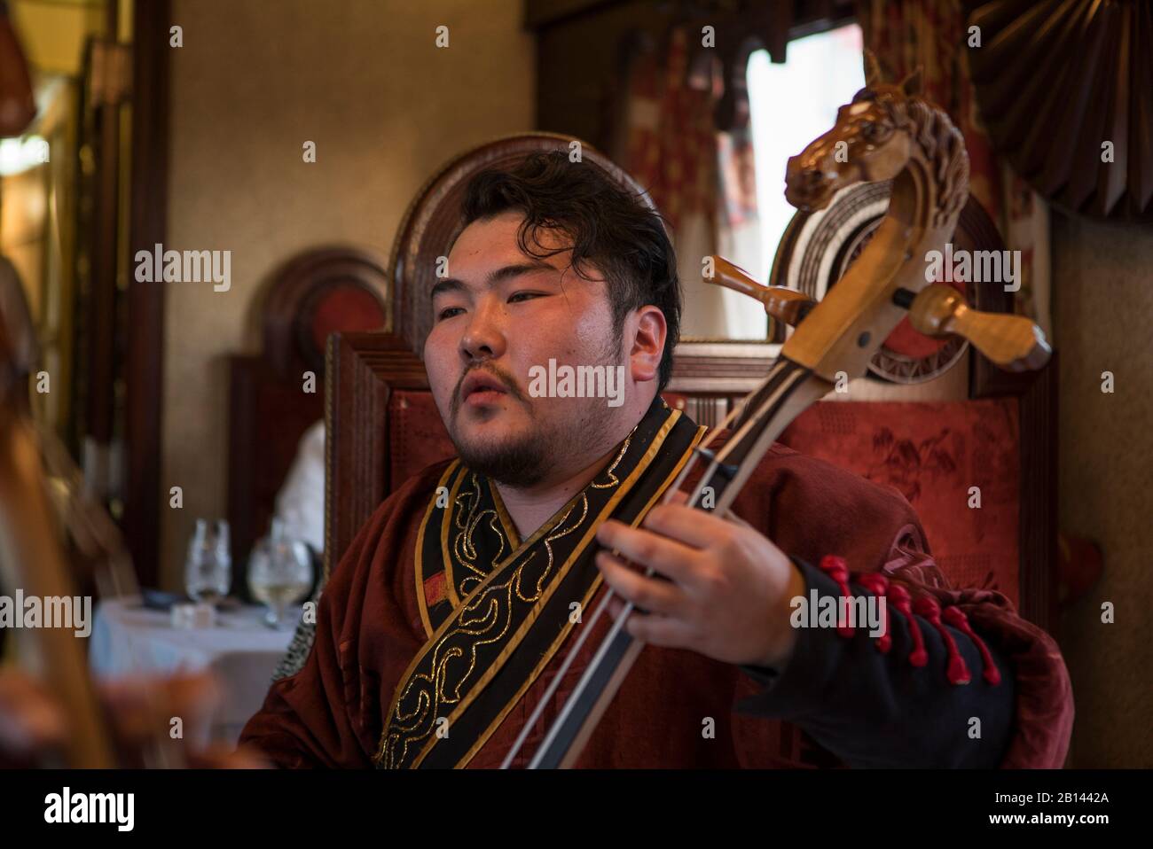 Mongole suona lo strumento nella carrozza ristorante, Trans-Siberian Ferroviaria di ferro Foto Stock