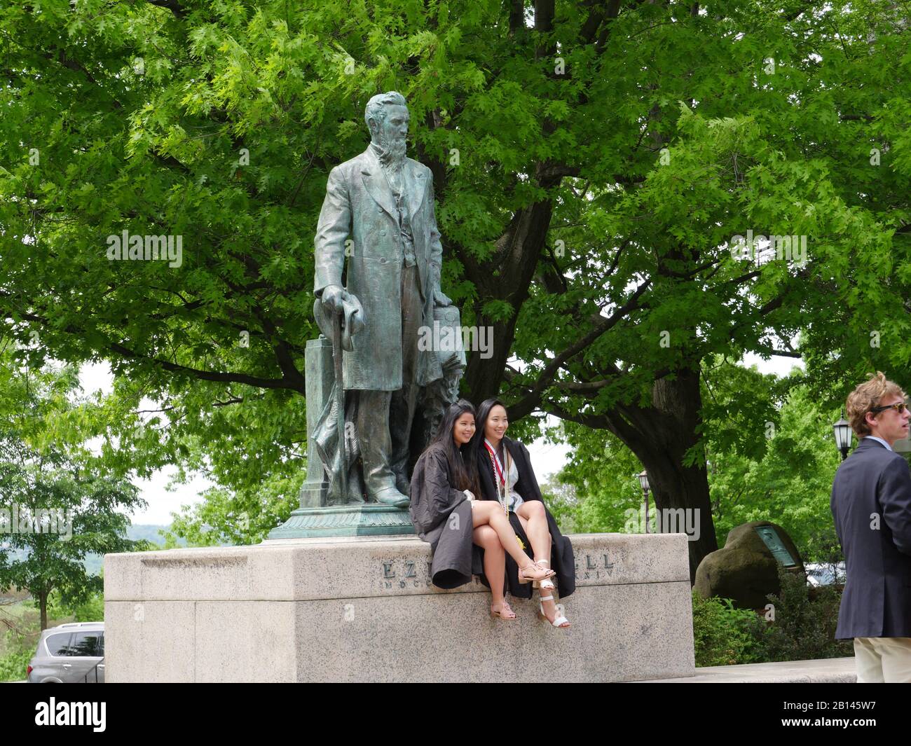 Cornell University, Ithaca, giornata di laurea, studenti in posa con la statua del fondatore Foto Stock