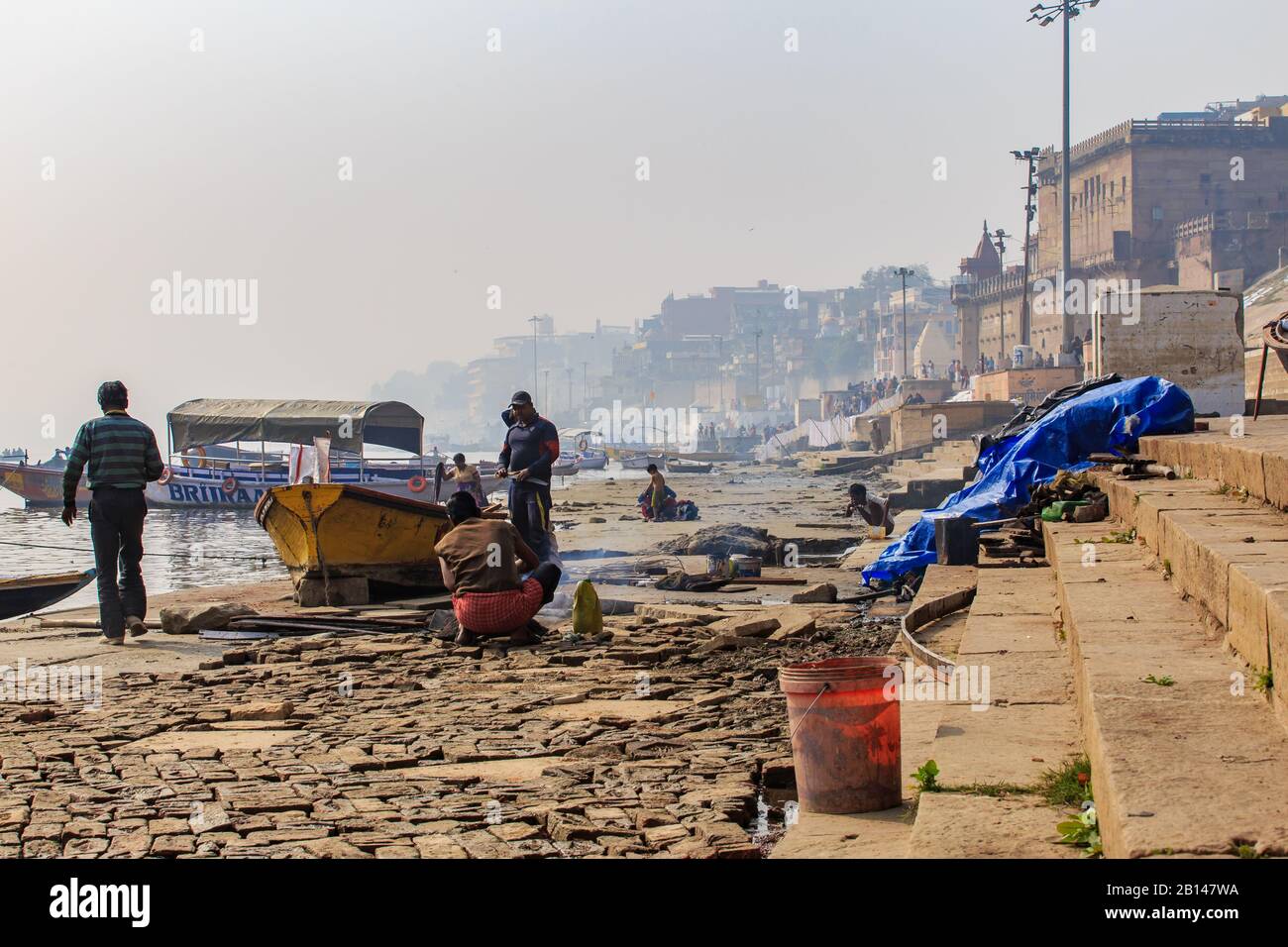 Varanasi, INDIA - 29 GENNAIO 2020: Vita mattutina casuale indiana sul fiume Ganga a Varanasi. Una barca sotto riparazione. Foto Stock