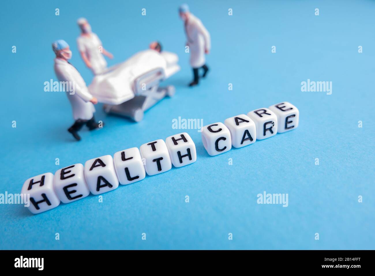 Mini giocattolo medico persone - cure mediche frasi con sfondo blu o teale Foto Stock