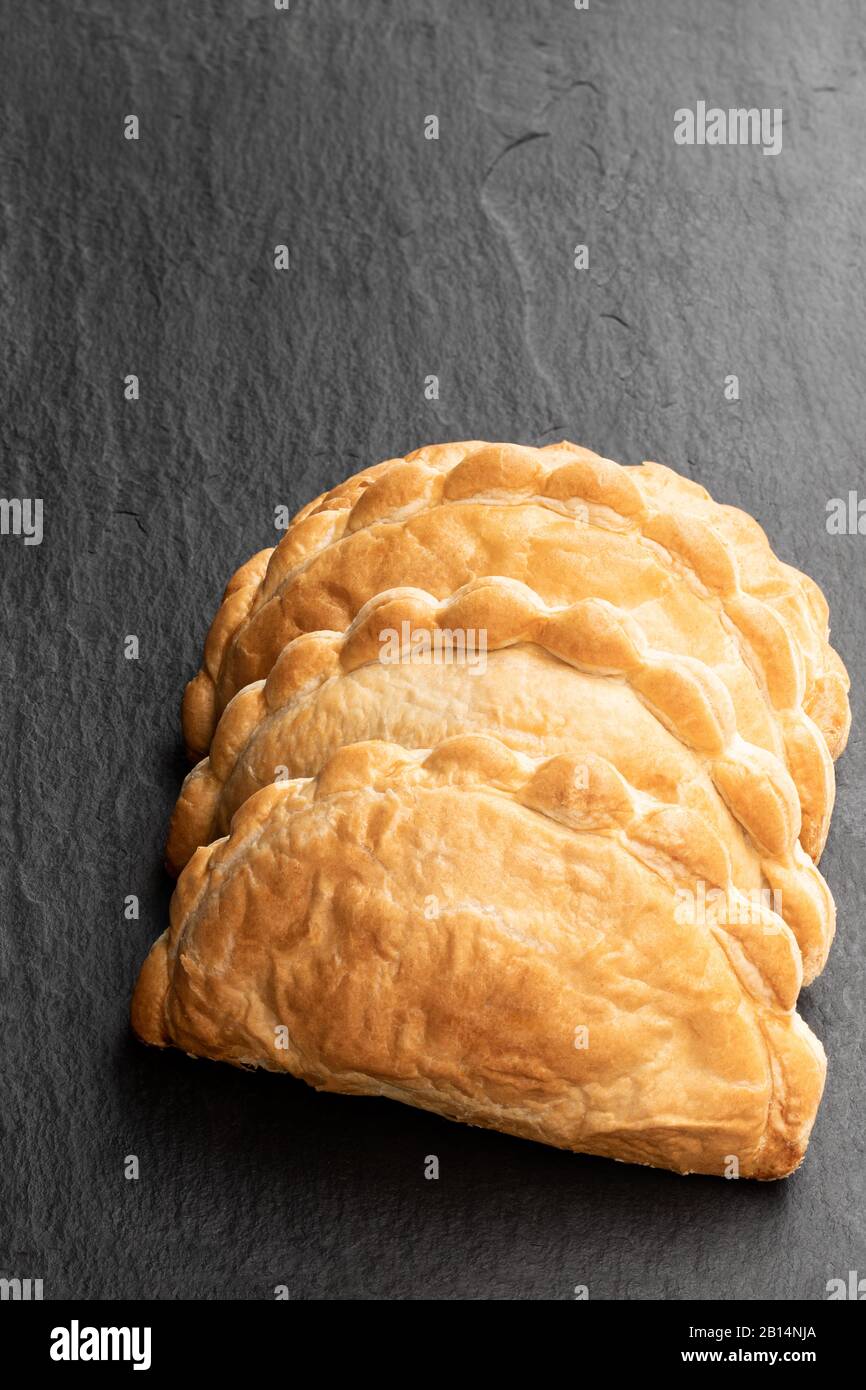 Pasta friabile fatta in casa con carne di mince ripieno su sfondo di pietra nera Foto Stock