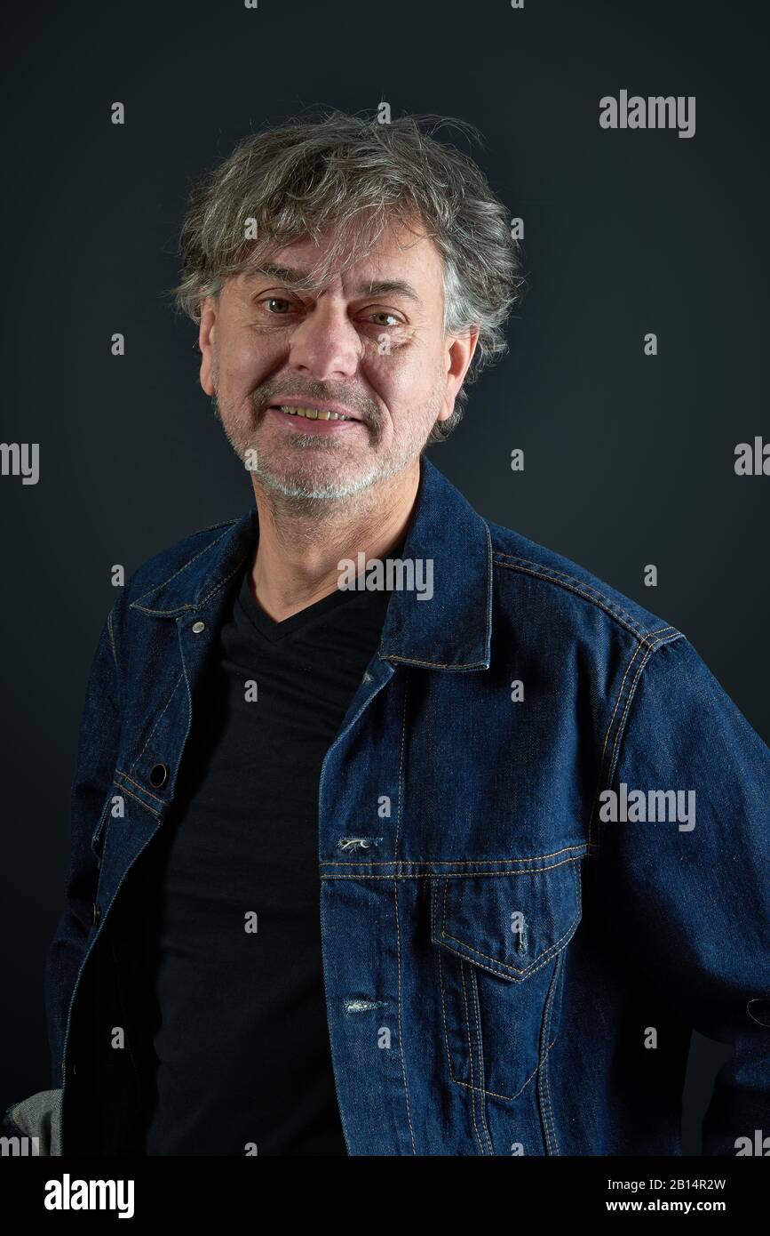 Ritratto di un uomo con giacca in denim blu su sfondo sfumato Foto Stock