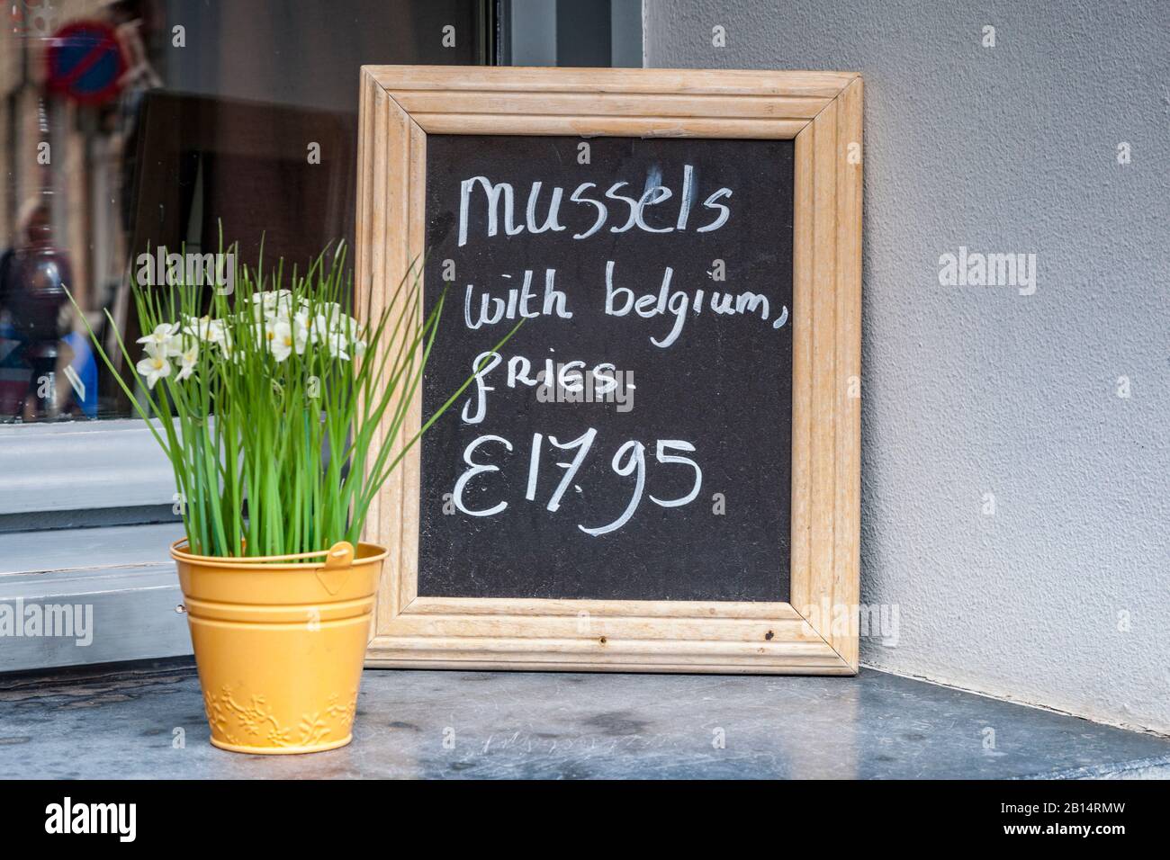 25 settembre 2018: Bruges, Belgio - Accedi al ristorante esterno di Bruges facendo pubblicità al famoso pasto belga di cozze con patatine fritte, moules avec frites. Foto Stock