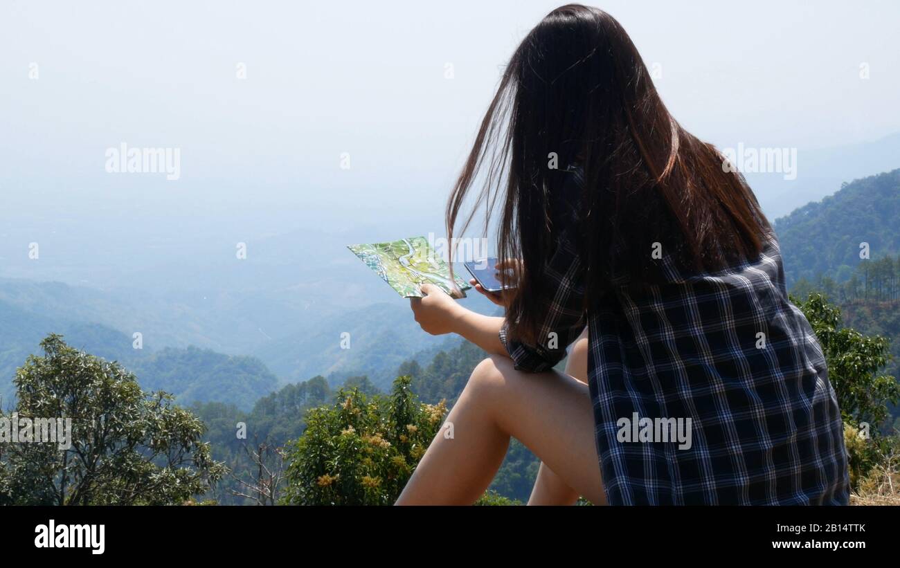 Tecnologia con applicazione sul telefono cellulare. Donna turistica asiatica utilizzare l'applicazione touchscreen su smartphone cellulare e mappa per cercare la guida del tour Foto Stock