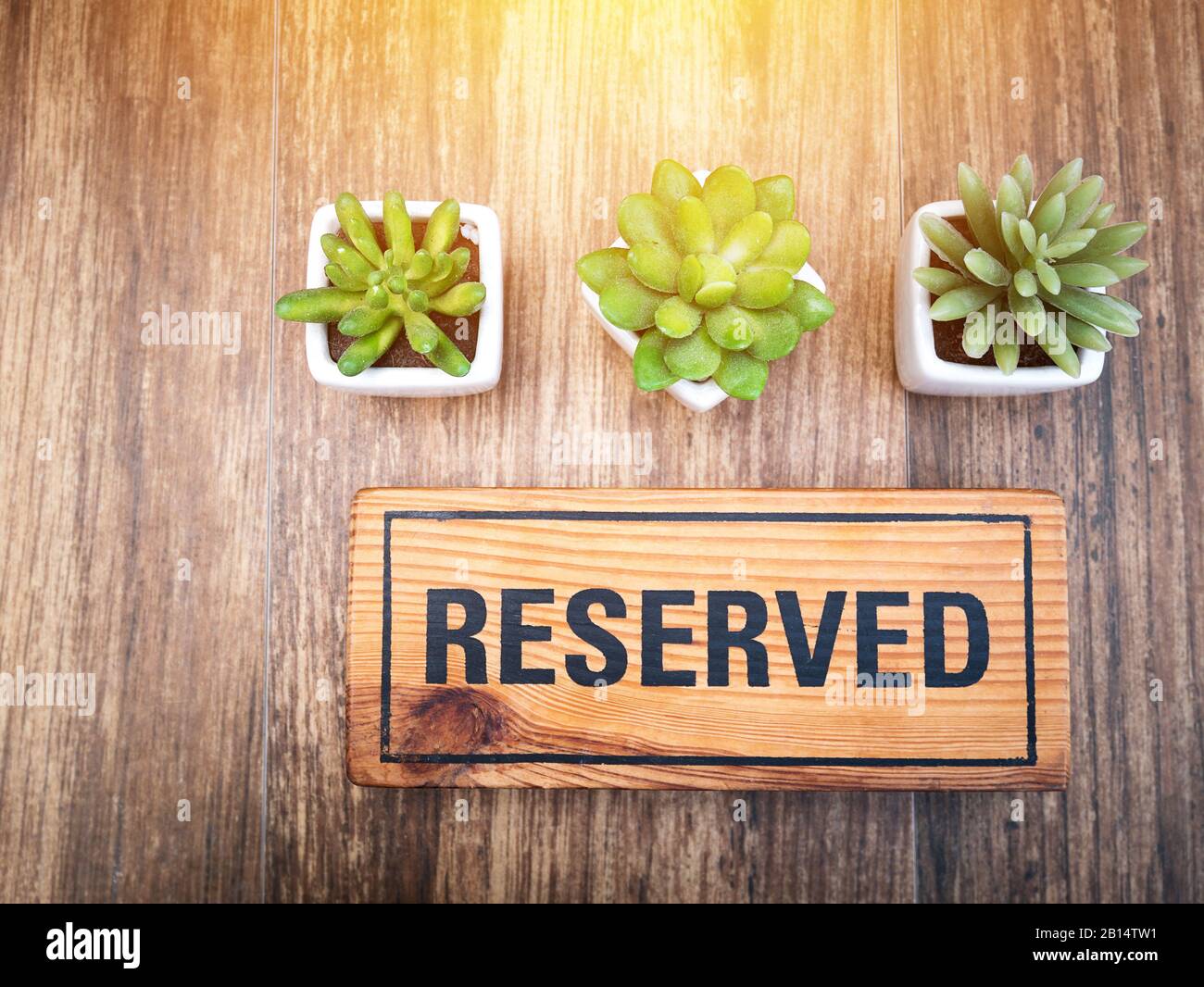 Cartello in legno riservato sulla cima di un tavolo in legno in un ristorante, posto per prenotazioni al ristorante per incontri su tema festeggiato. Segno riservato da Foto Stock