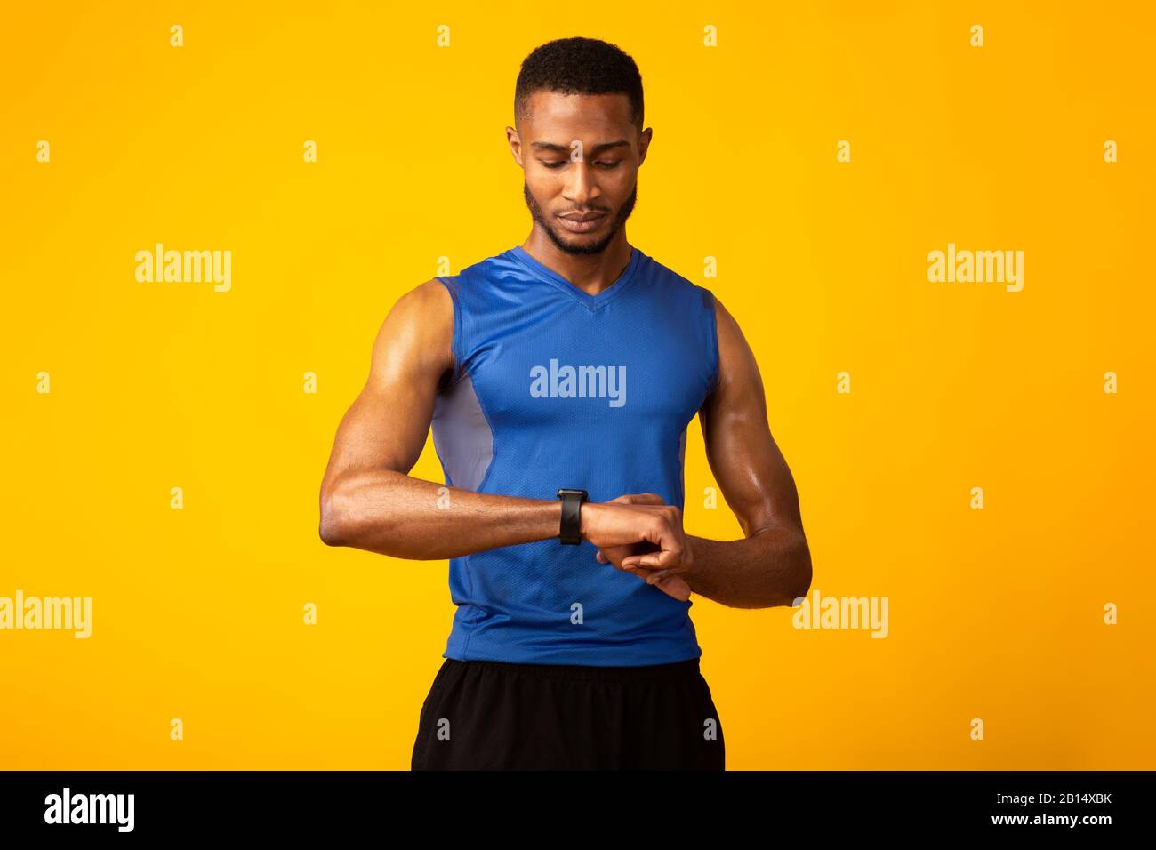 Sicuro afro ragazzo guardando il suo smart watch Foto Stock