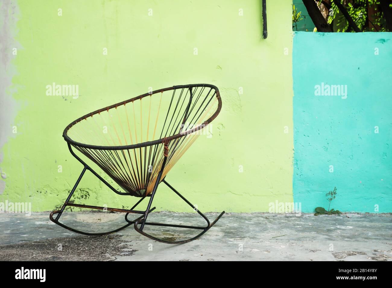 Tipica sedia a dondolo messicana fatta in casa su parete verde blu Foto Stock