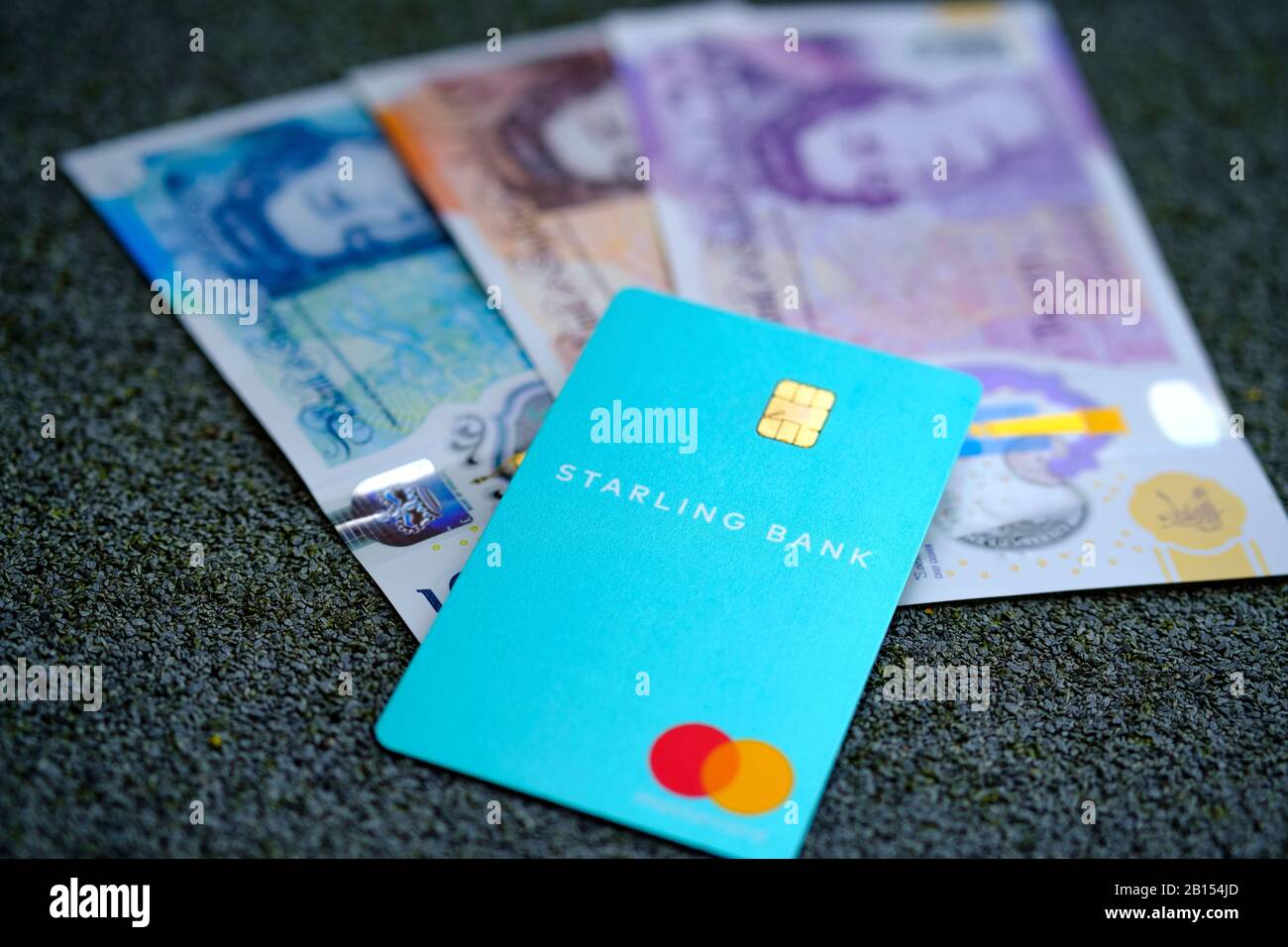Carta Starling Bank e contanti sfocati sullo sfondo. Messa a fuoco selettiva. Foto Stock