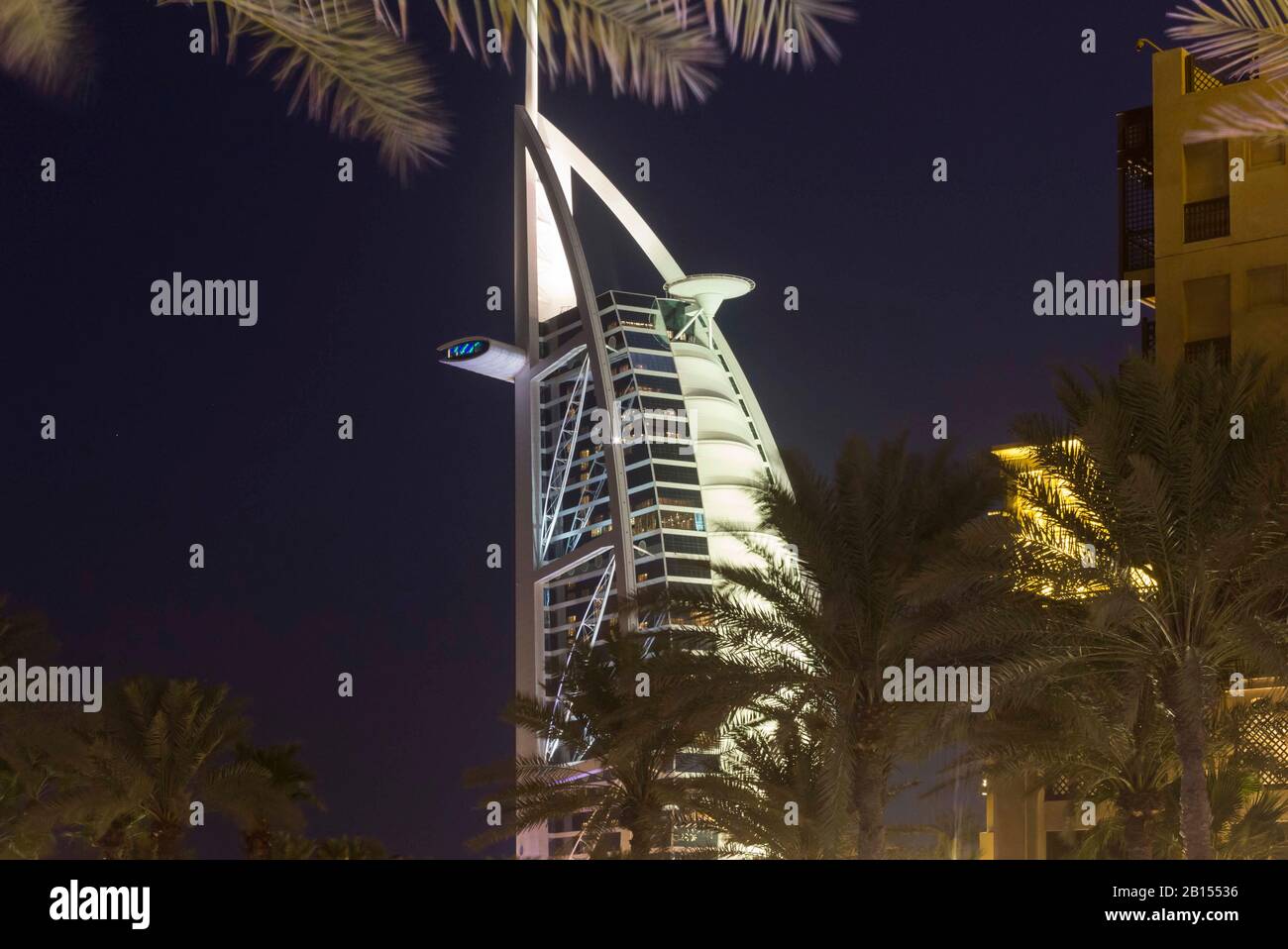 Dubai, Emirati Arabi Uniti - 29 DICEMBRE 2017: Vista notturna del Burj al Arab Resort dietro le palme Foto Stock