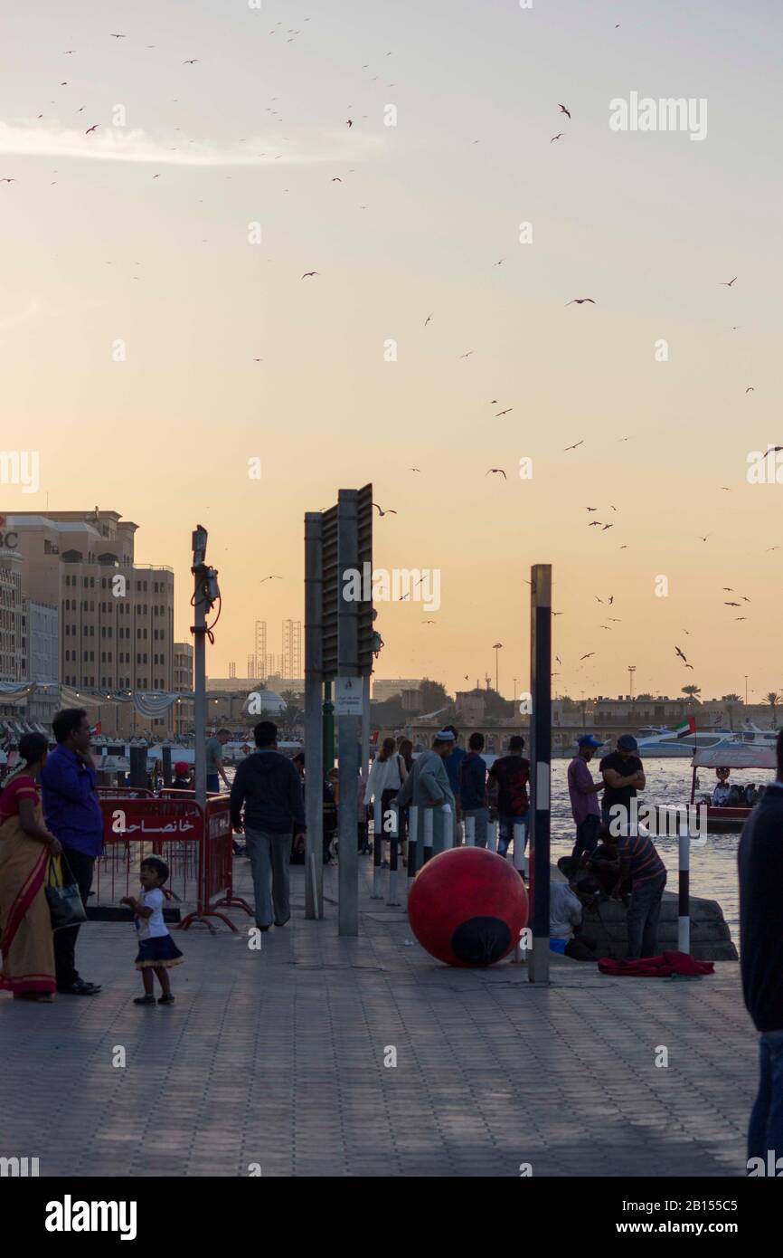 Dubai, Emirati Arabi Uniti - 30 DICEMBRE 2017: Persone che camminano al tramonto sul Dubai Creek Foto Stock