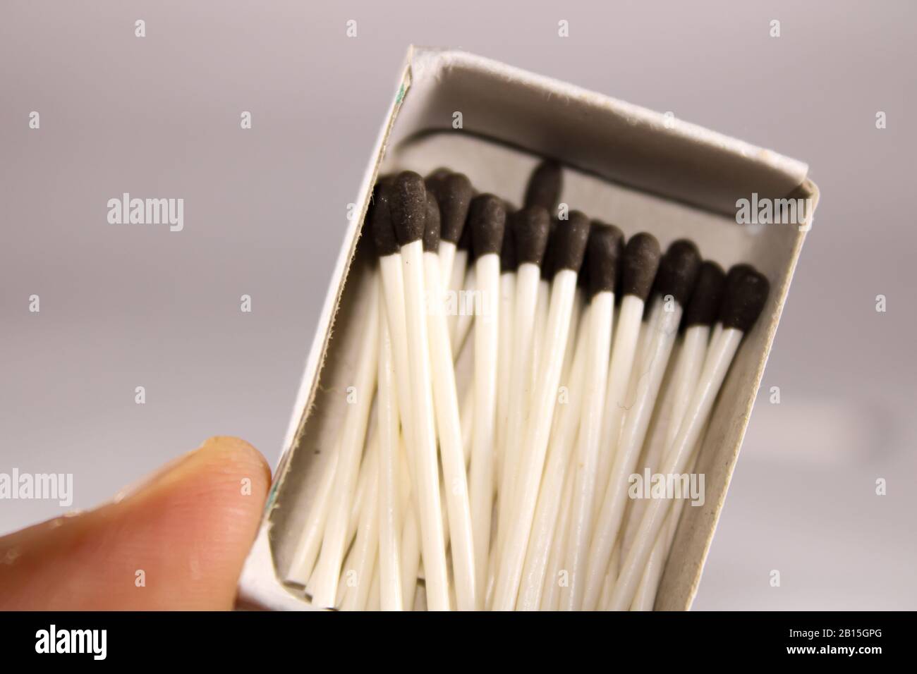 Un concetto creativo di una scatola di corrispondenza di cera con bastone e testa nera Foto Stock