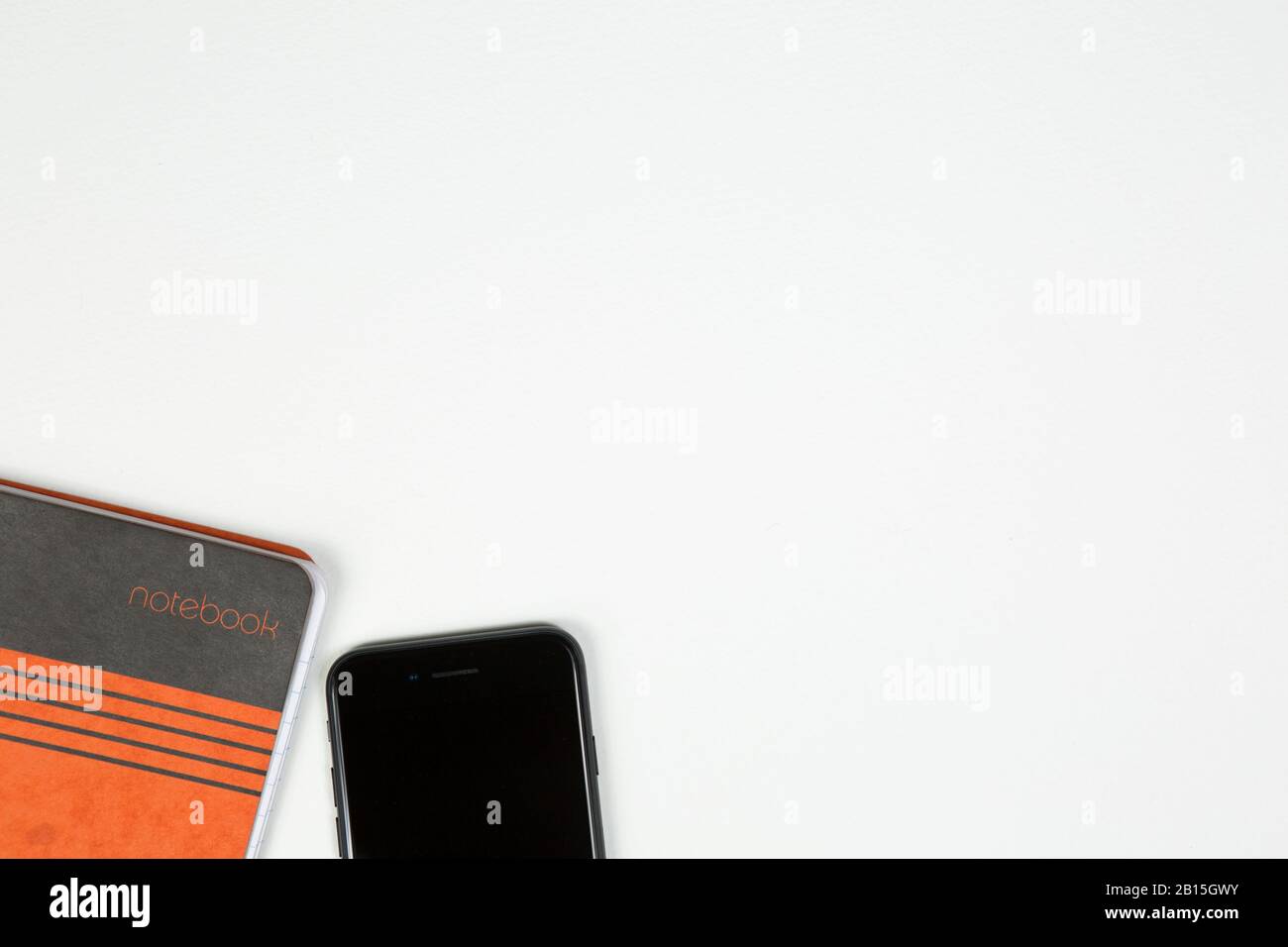 Smartphone per cellulare e vista dall'alto del notebook con sfondo bianco copyspace. Lavoro dal concetto domestico di riunione di affari Foto Stock